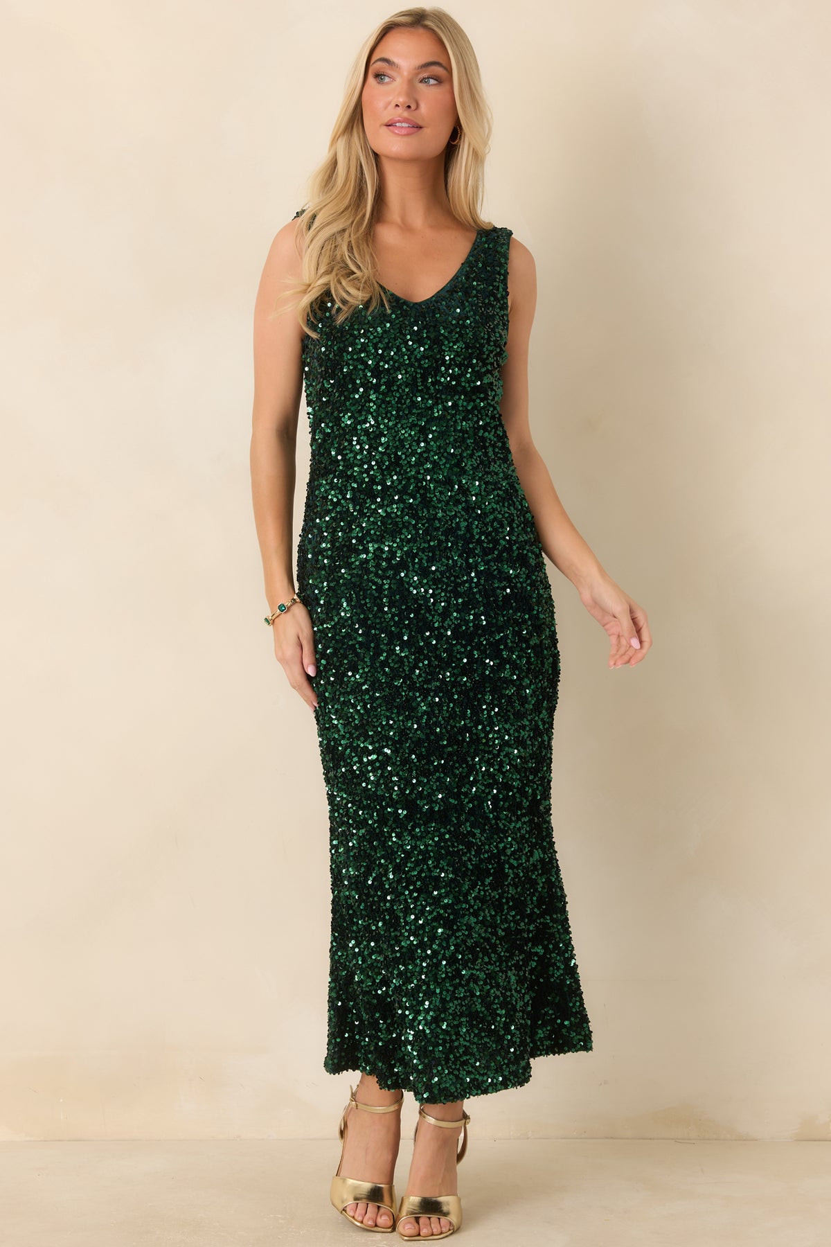 Emerald green dress with reflective sequins, a sleeveless cut, and a softly curved neckline.