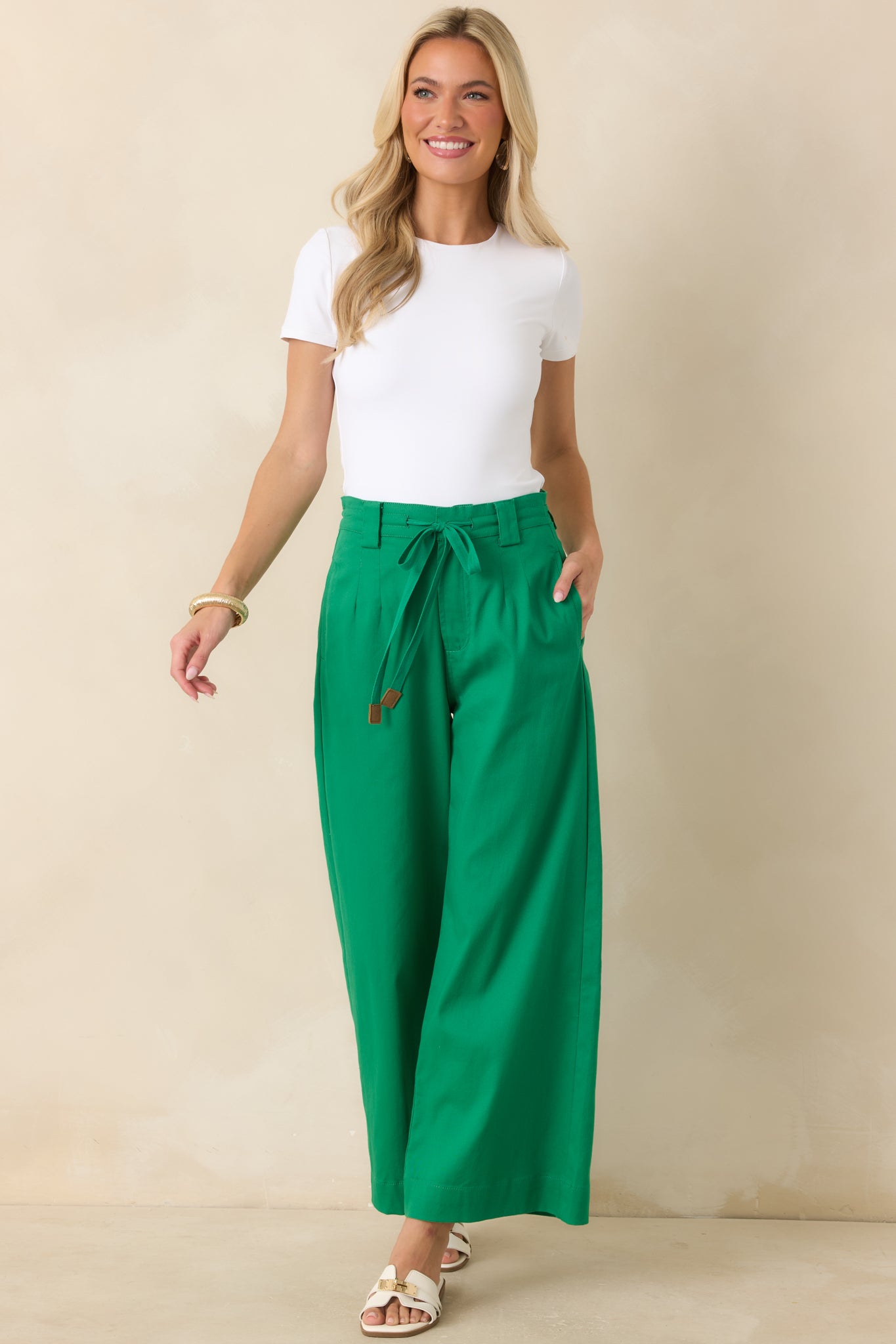 Emerald green high-rise wide leg pants featuring a removable tie belt, front pleats, and tailored silhouette.