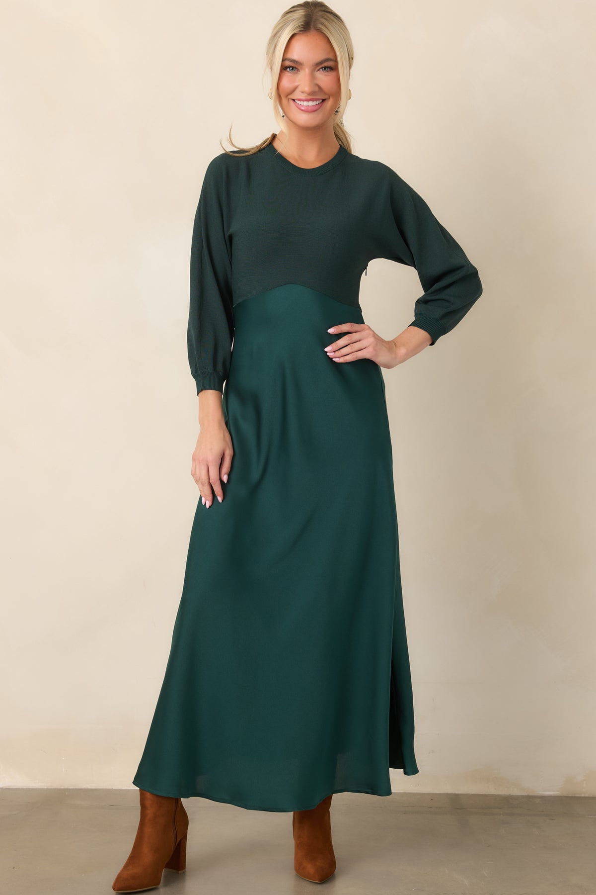 Two-texture emerald dress pairs a fitted knit top with a smooth satin A-line skirt that falls to midi length.