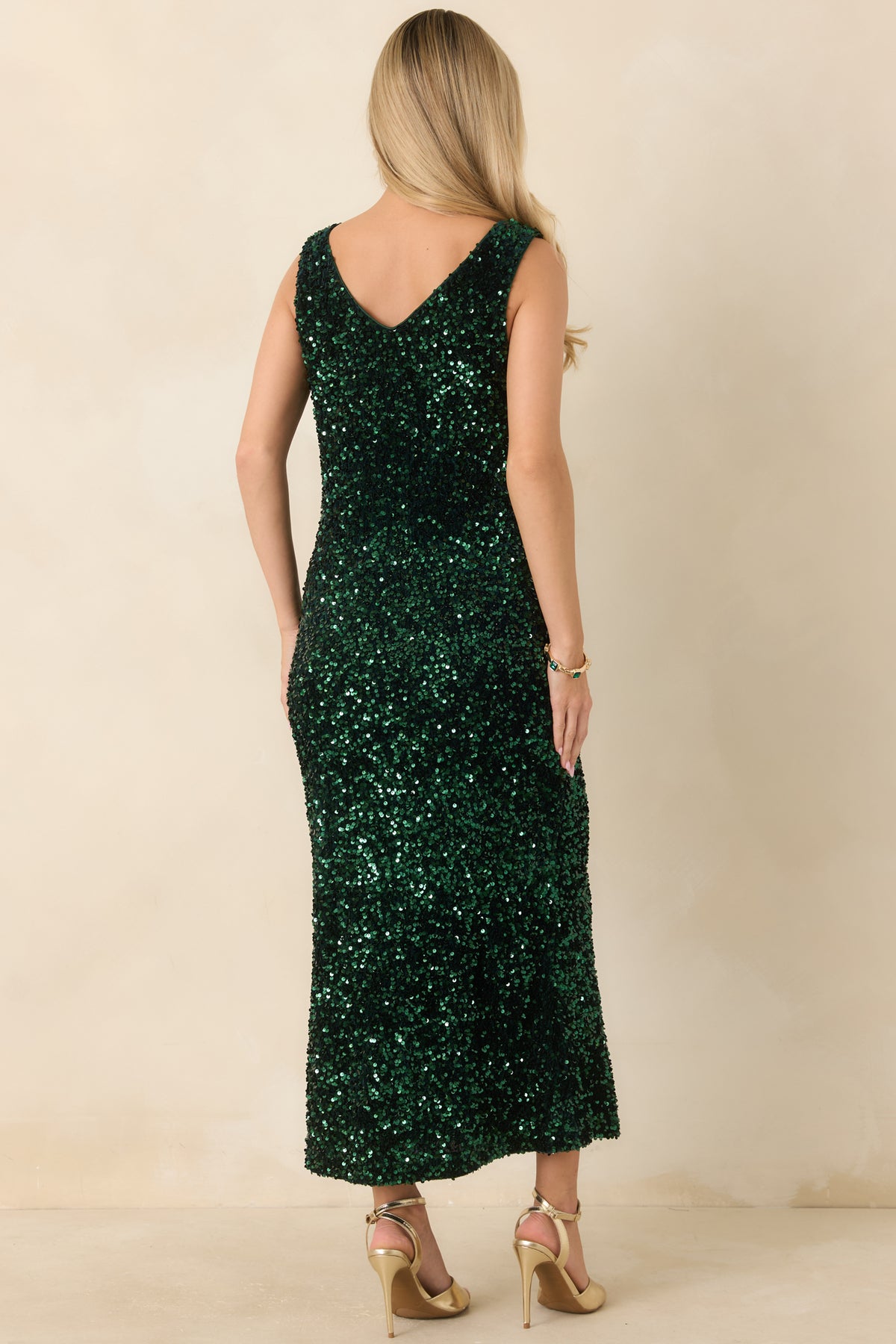Rear view of the emerald green sequin midi dress featuring a matching V-back and wide shoulder straps.