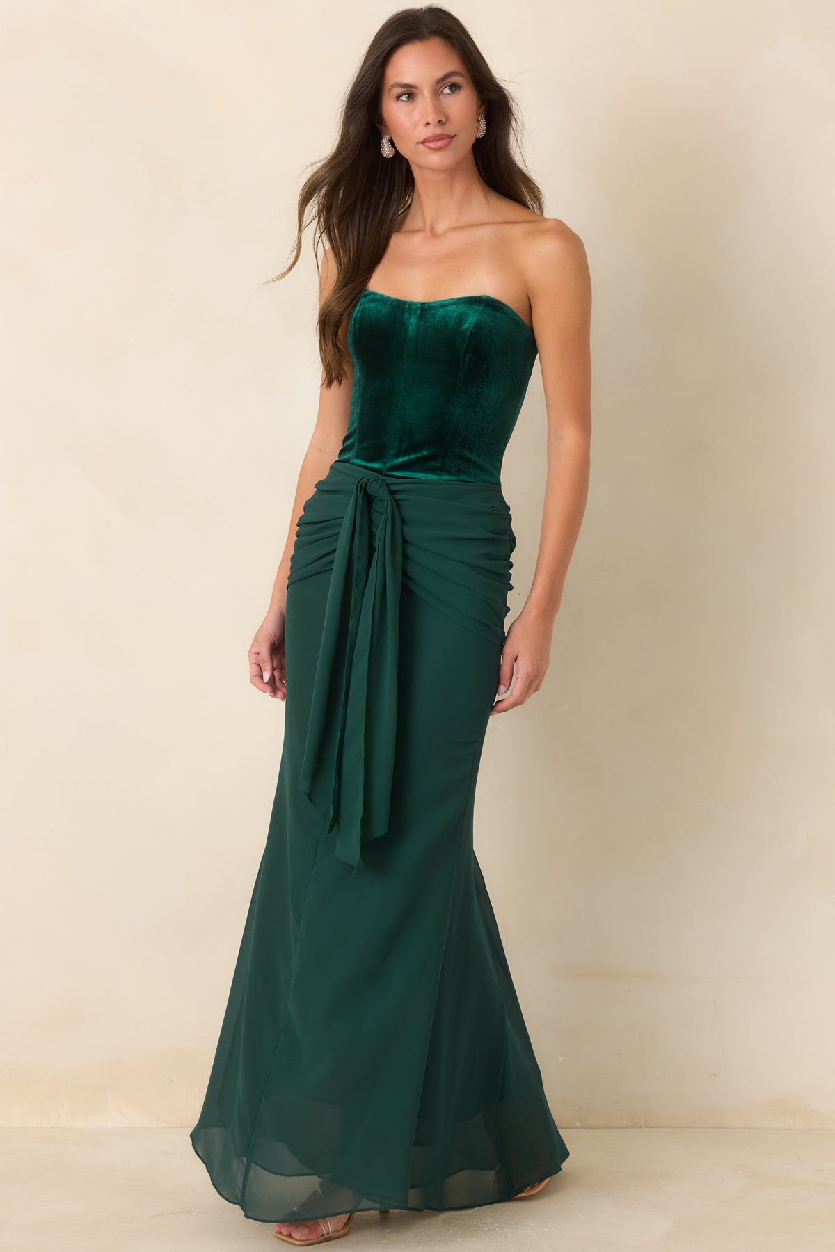 Rich emerald strapless dress with boning through the bodice and ruching at the hips.