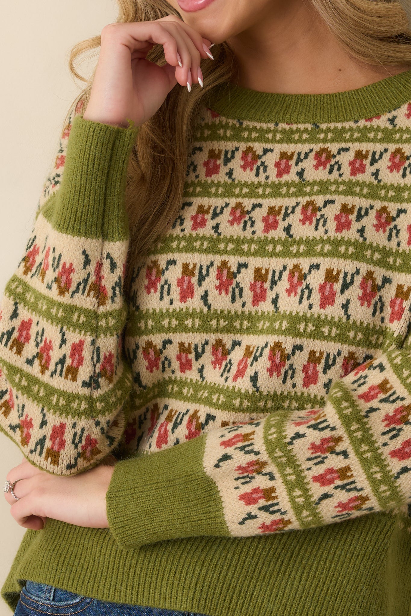 Detailed view of the Fair Isle pattern in ivory, rust, and green on the olive green knit sweater.