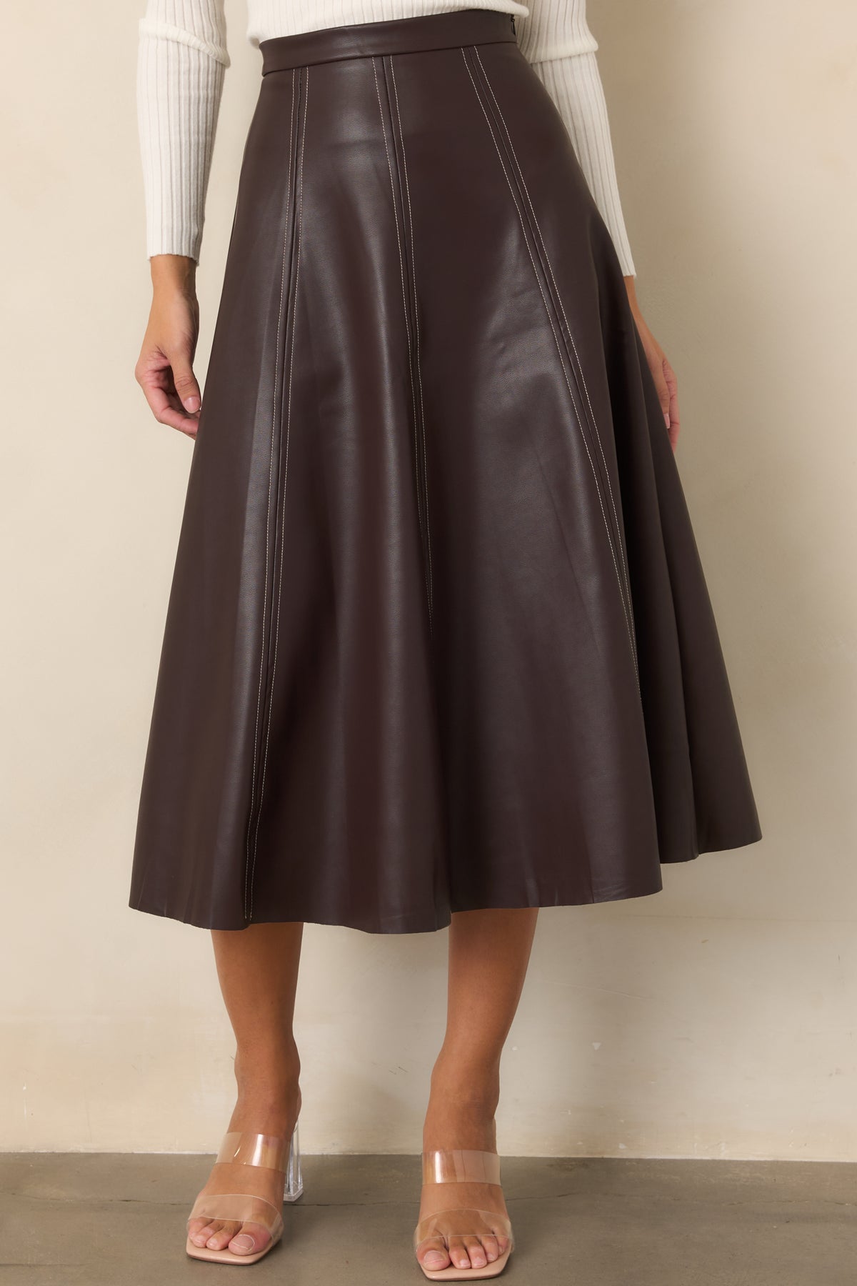 Faux leather skirt displaying the clean waistband and dimensional panel construction.