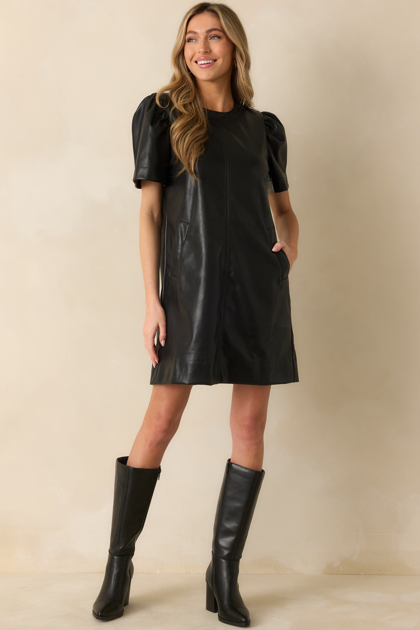 Soft-sheen faux leather dress showing its structured A-line shape and smooth vertical seams.