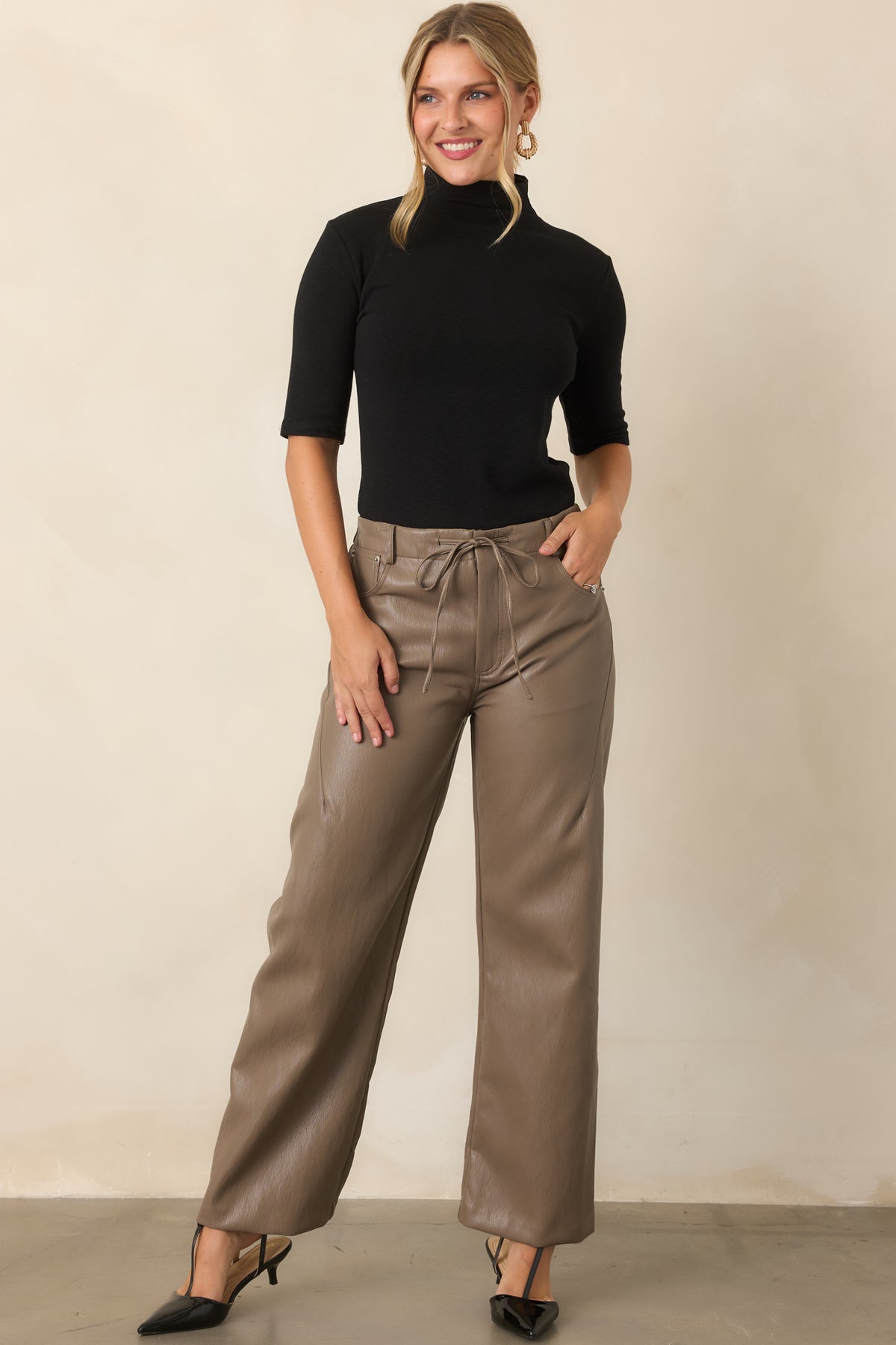 Faux leather pants showcasing a relaxed wide-leg shape and comfortable elastic waistband.