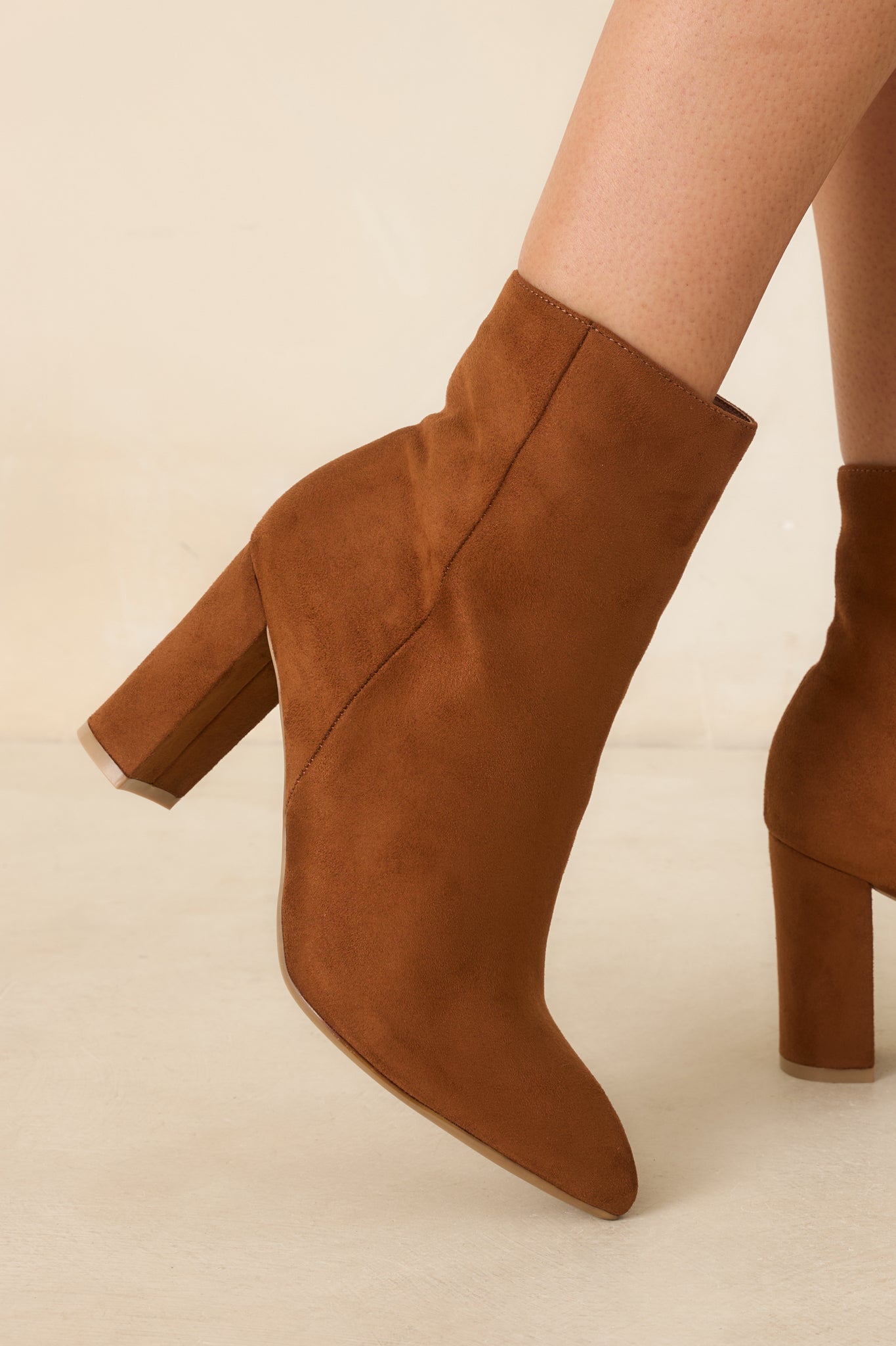 Faux suede ankle boots in a warm cinnamon brown shade with a functional inner zipper and streamlined silhouette.