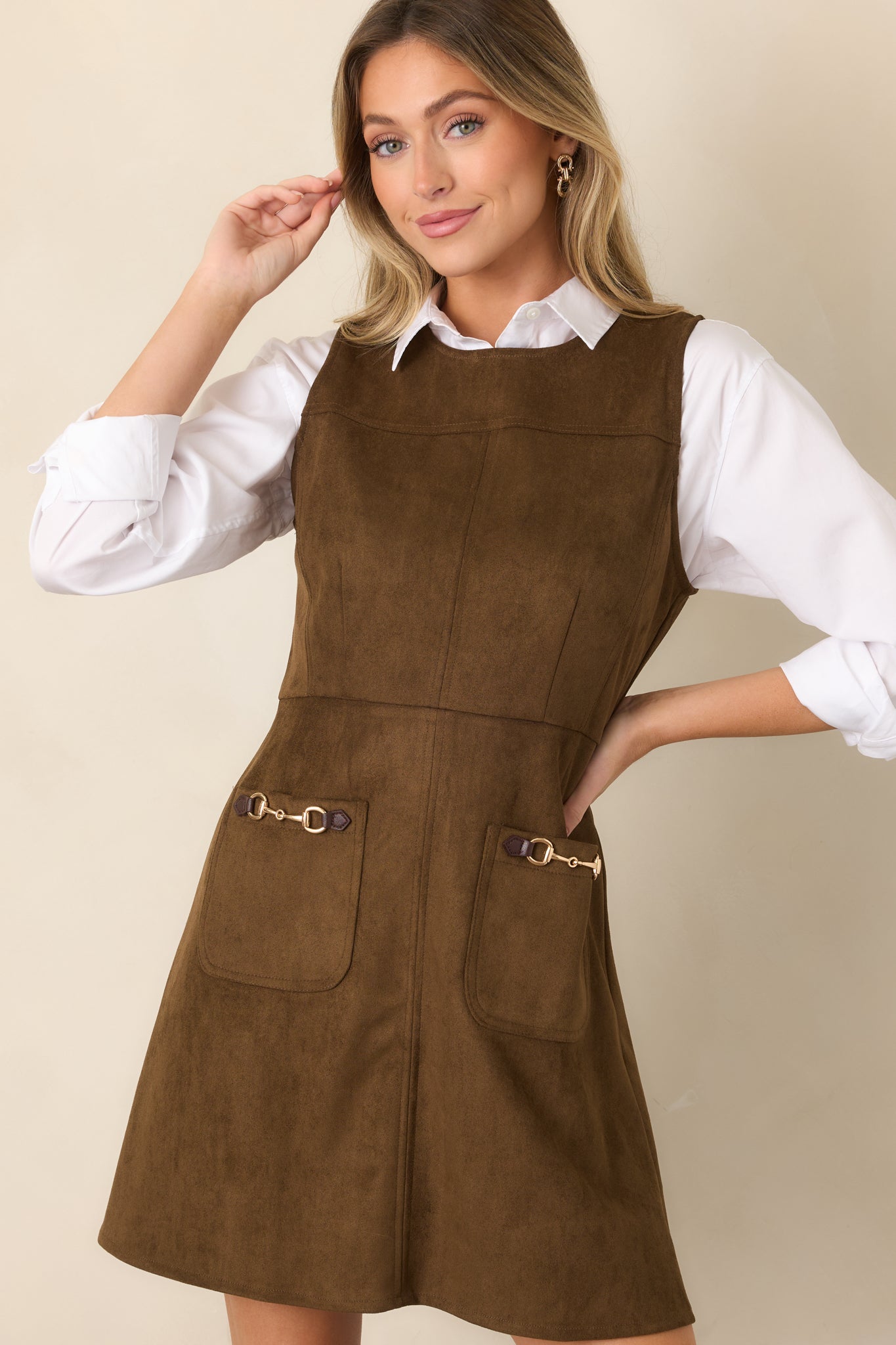 Faux suede dress highlighting the polished front pocket design with gold-tone equestrian-inspired hardware and clean structured construction.