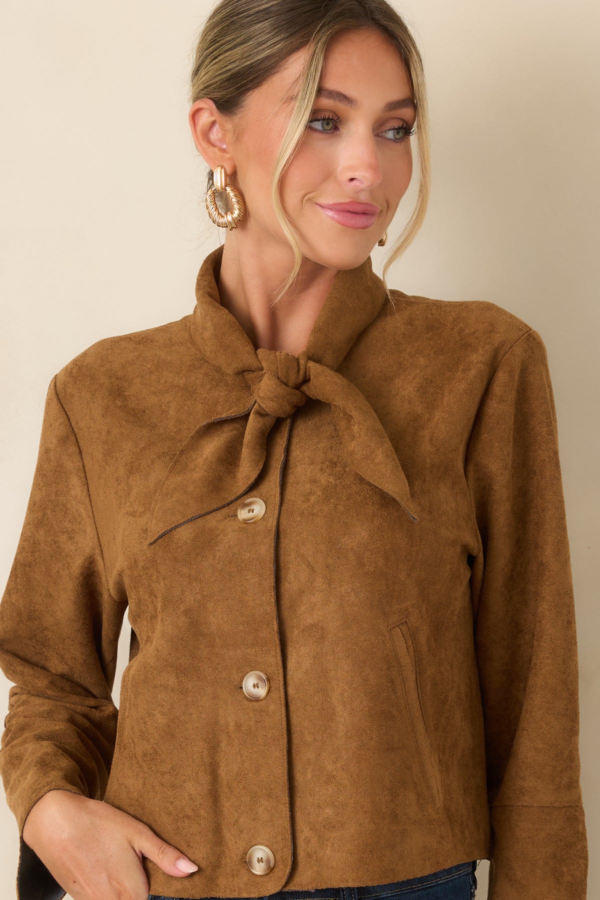 Detailed view of the faux suede jacket showcasing the welt pockets, button-front closure, and softly structured construction.