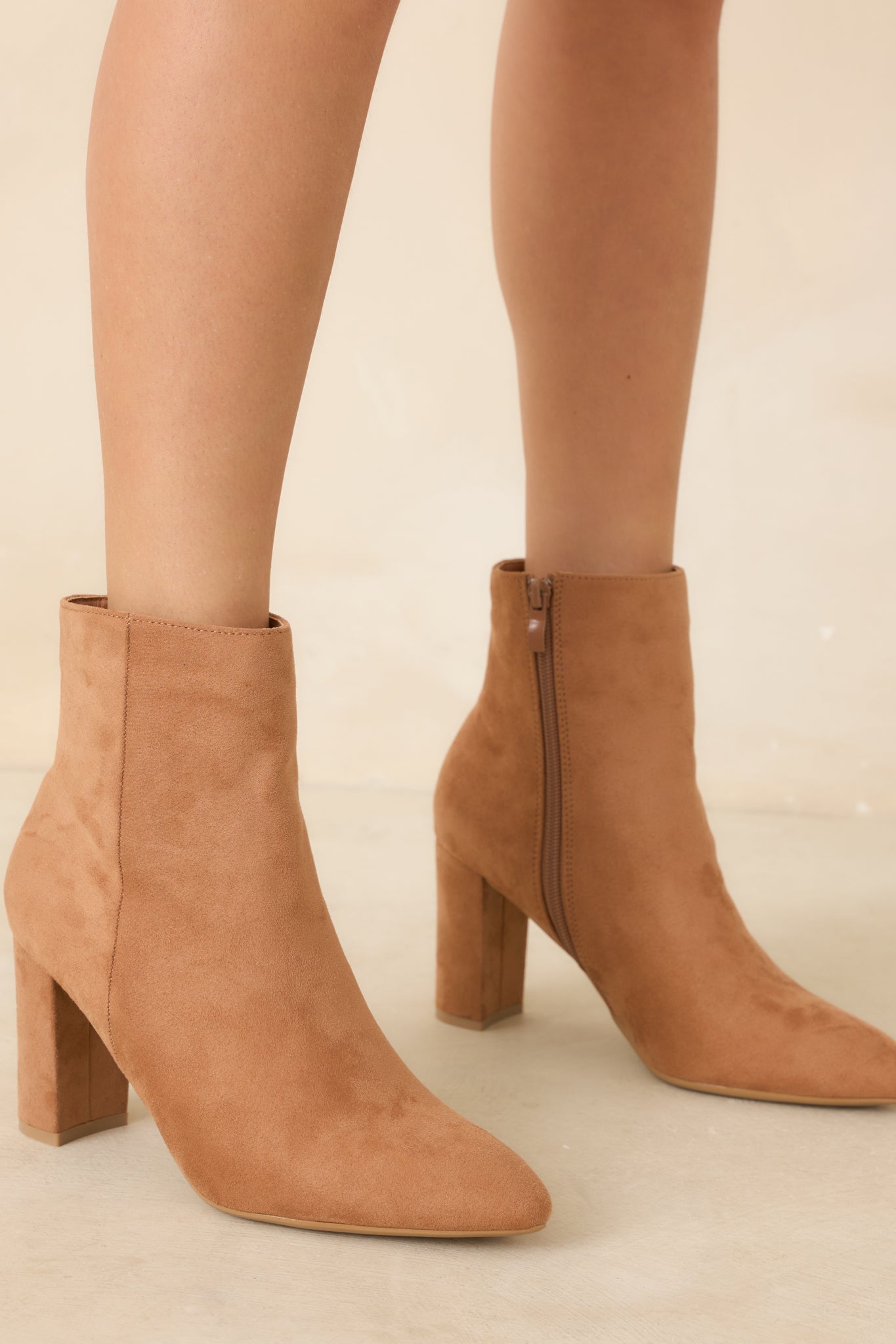Close view of the ankle boots highlighting the soft faux suede texture, pointed toe silhouette, and clean outer seam detailing.