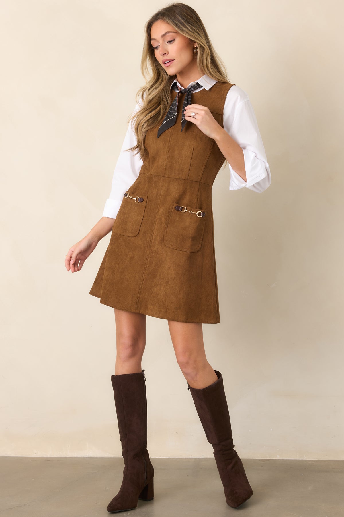 Soft faux suede mini dress featuring a sleeveless bodice, round neckline, structured seam detailing, defined waist, and gently flared skirt.
