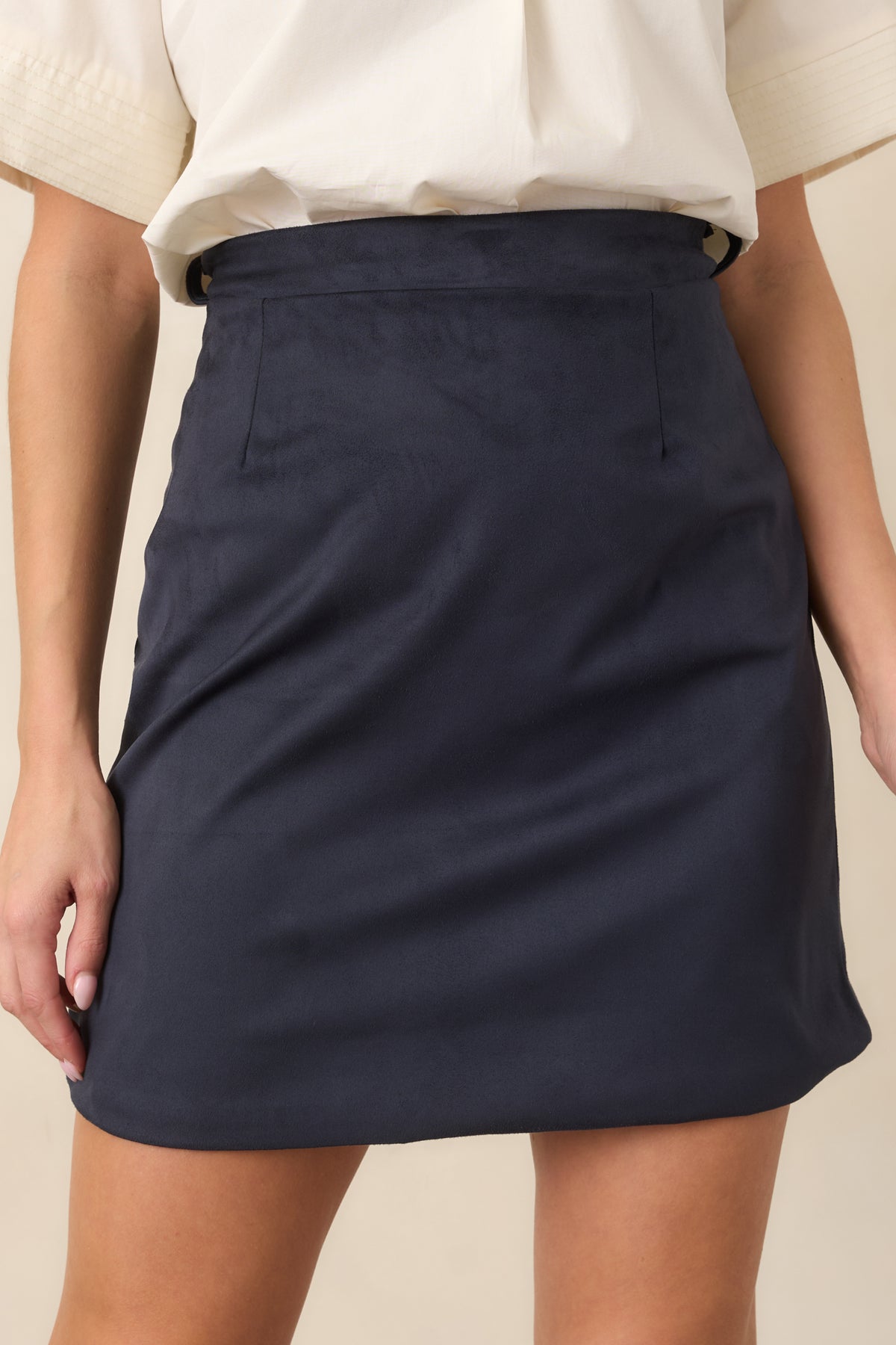 Close detailing highlights the faux suede texture, defined waistband, and subtle shaping darts.
