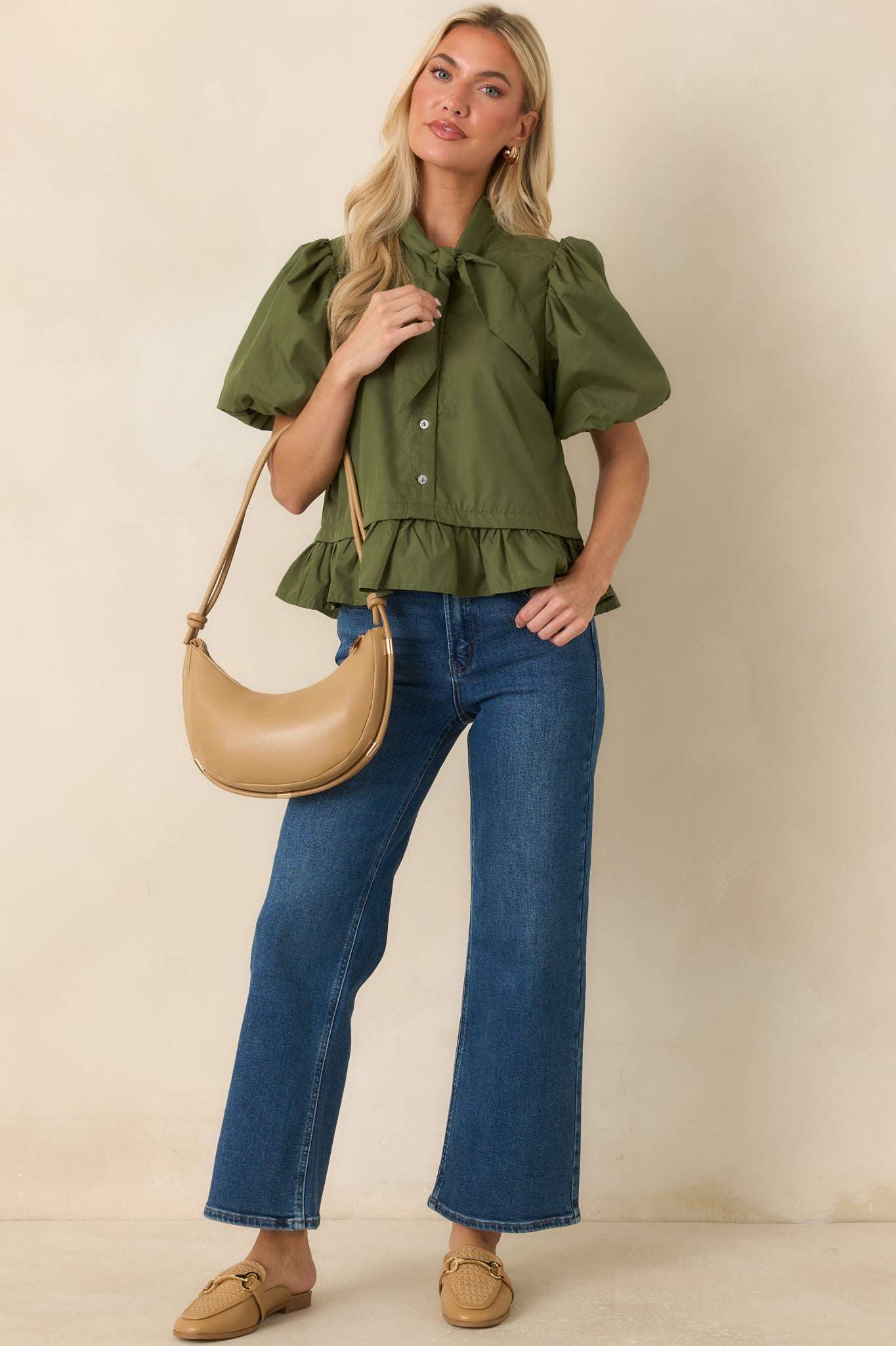 Feminine moss green top featuring a statement neckline, voluminous sleeves, and an elegant flounced hemline.