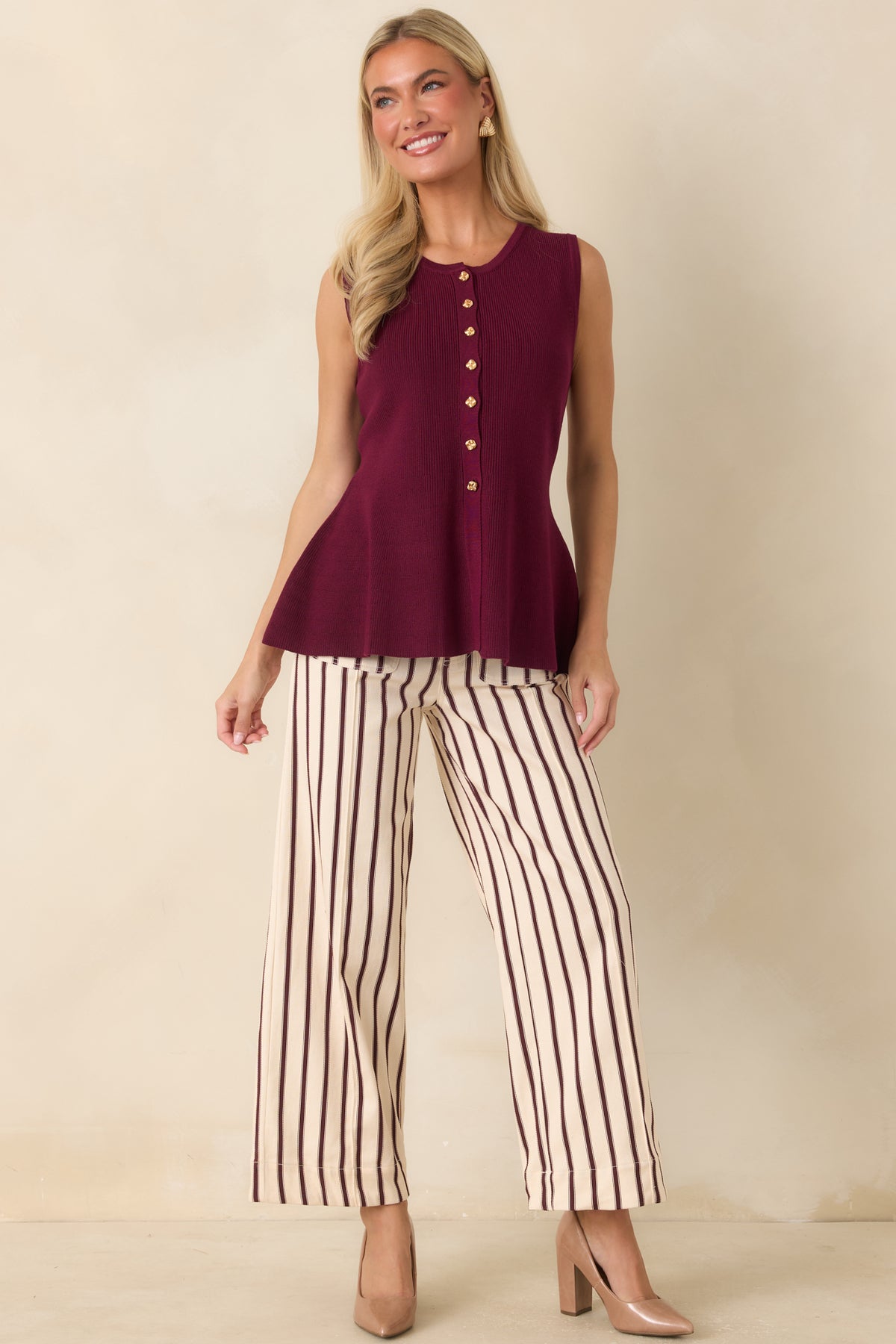 Feminine peplum top designed with a smooth knit finish, full button-front detailing, and a flattering silhouette.