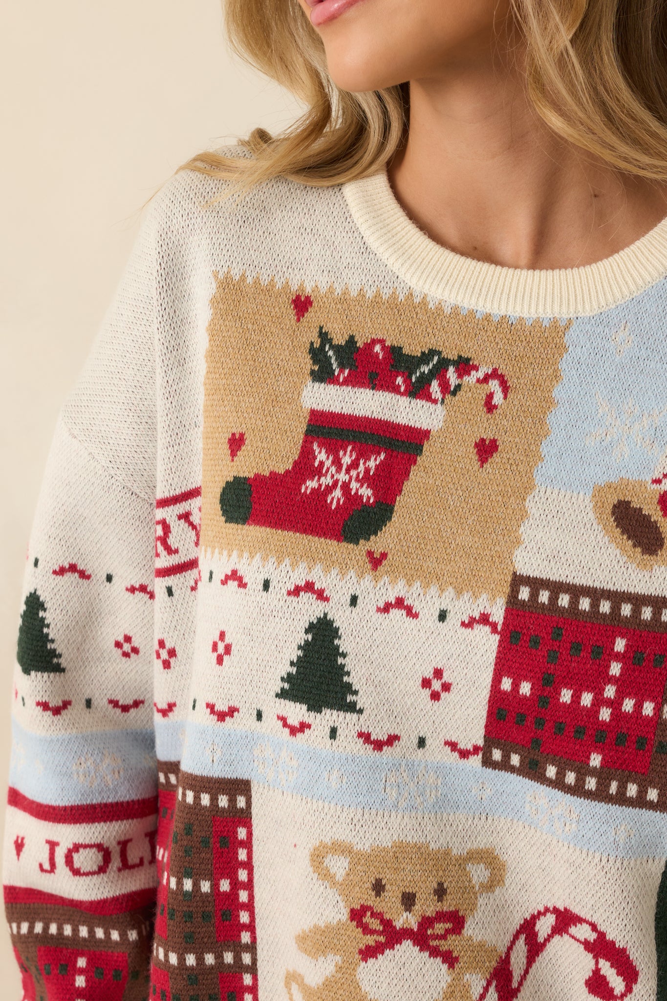 Detailed view of the festive patchwork knit featuring crisp, multi-color Christmas motifs and soft mid-weight texture.