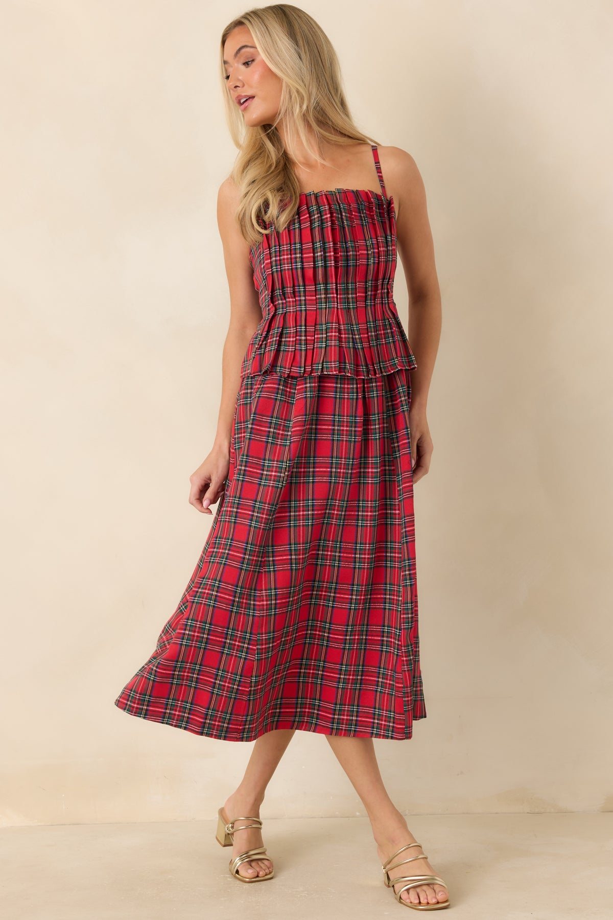 Festive red plaid dress with pleated bodice detailing and a flounced peplum waist.