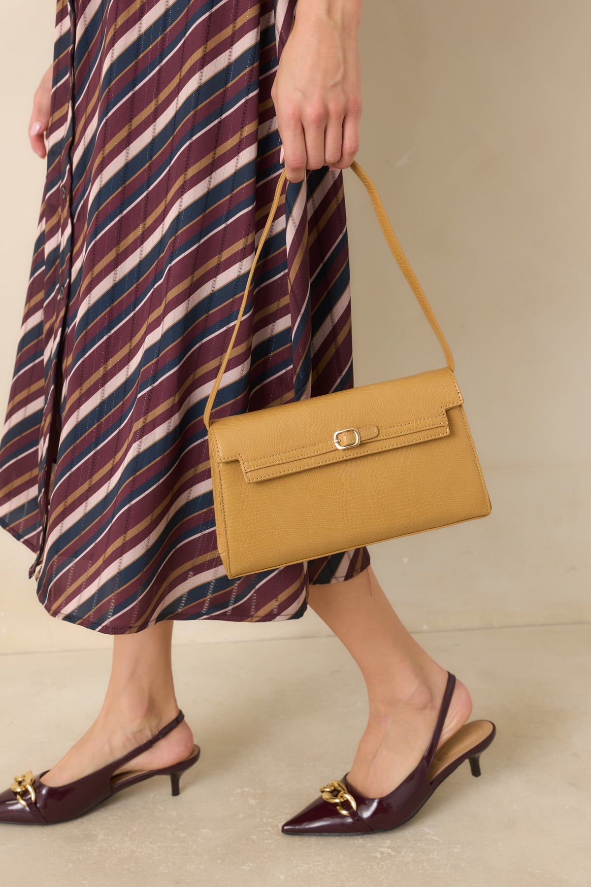 Fine-scale textured handbag featuring an envelope flap, slim belt accent, gold-tone buckle clasp, and slender shoulder strap.