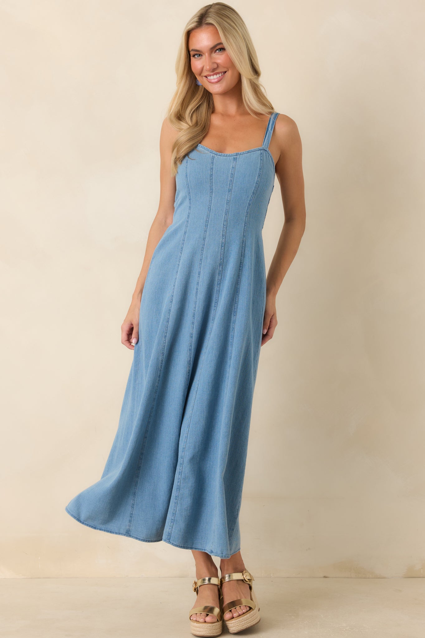 Fit-and-flare midi dress showcasing adjustable straps and an elongated silhouette created by vertical seams.
