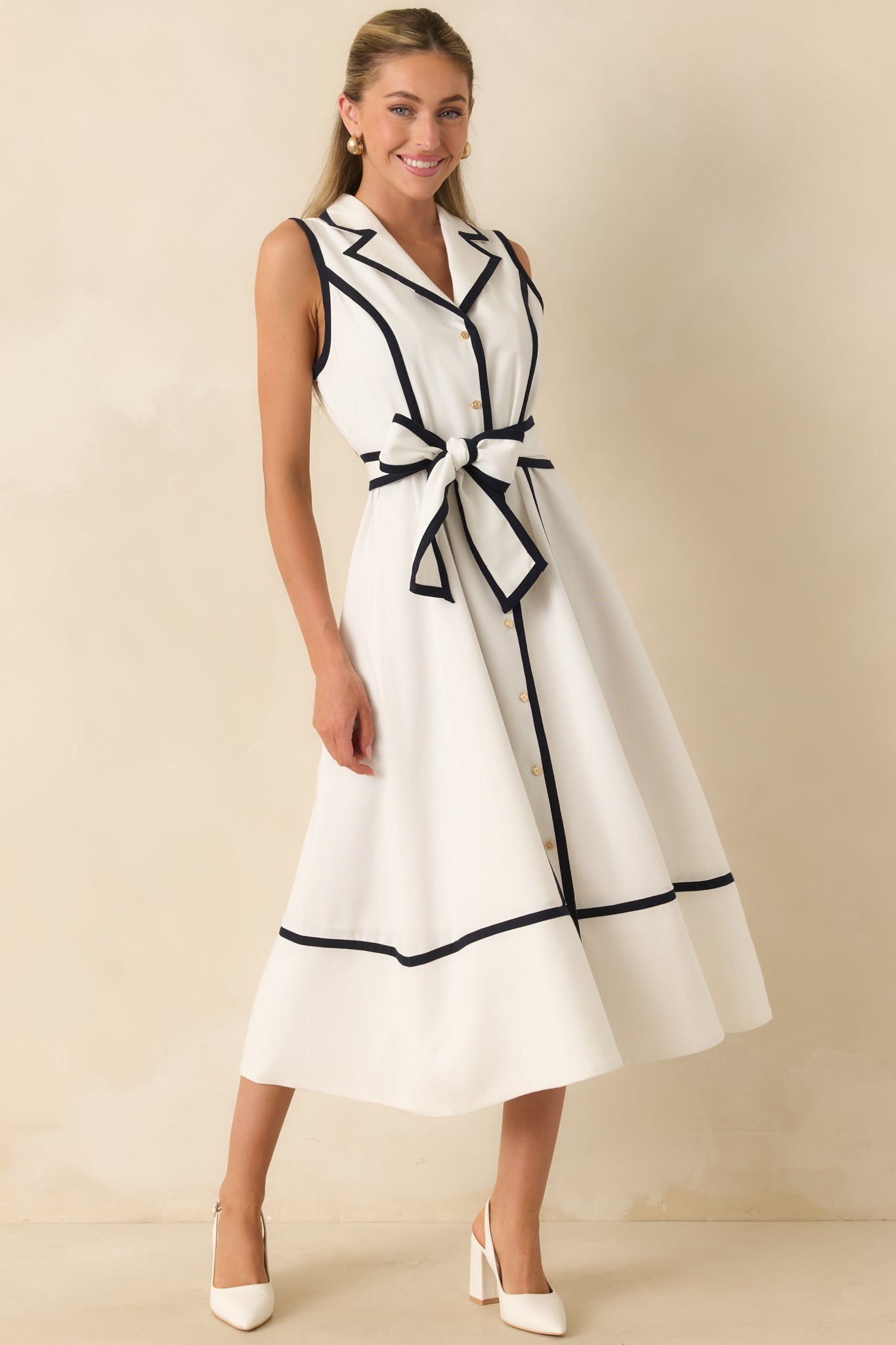 Sleeveless fit-and-flare midi dress showcasing a defined waist, self-tie belt, and full flowing skirt.