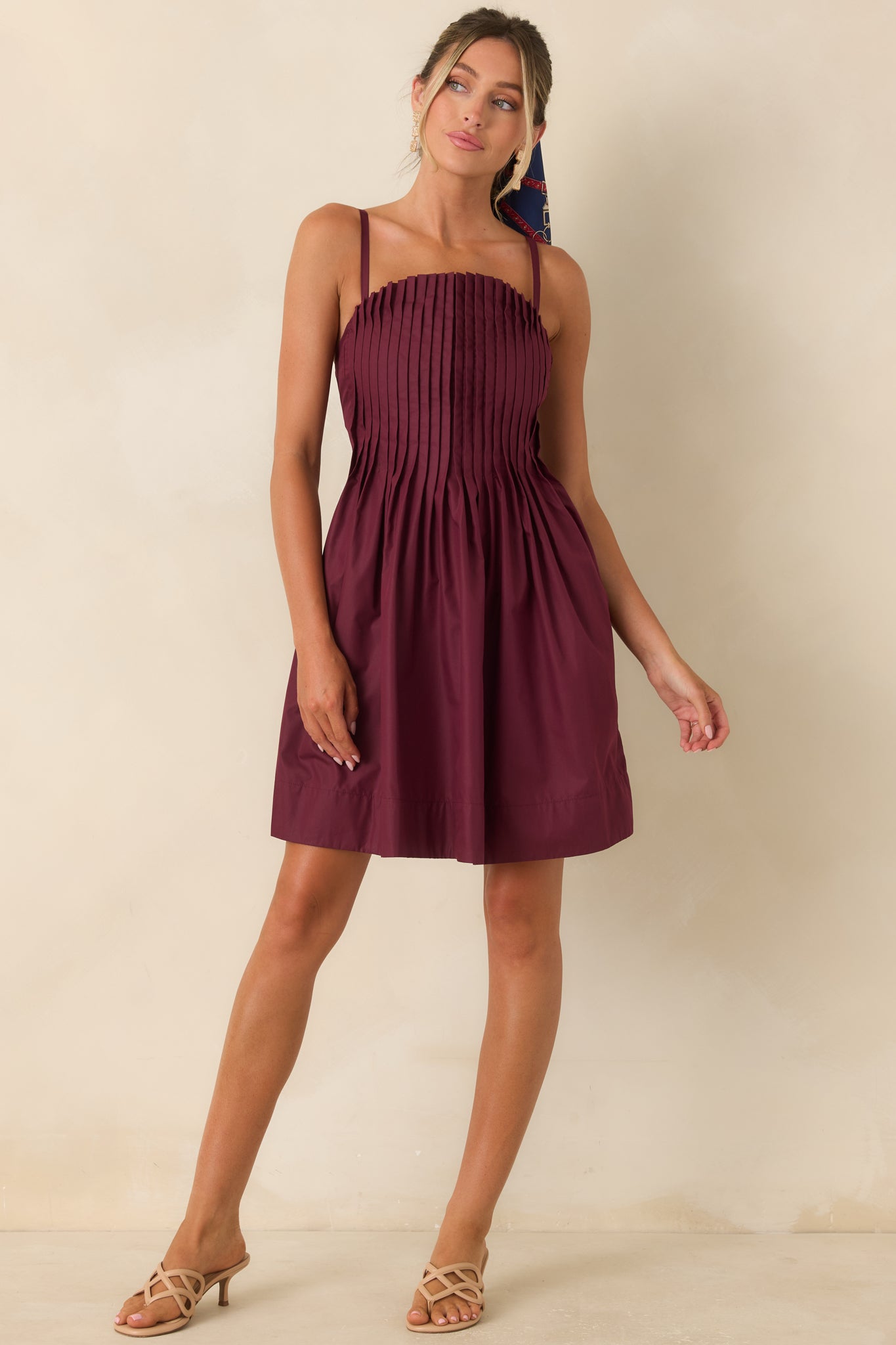 Fit-and-flare mini dress with crisp bodice pleats, adjustable shoulder straps, and a softly gathered skirt.