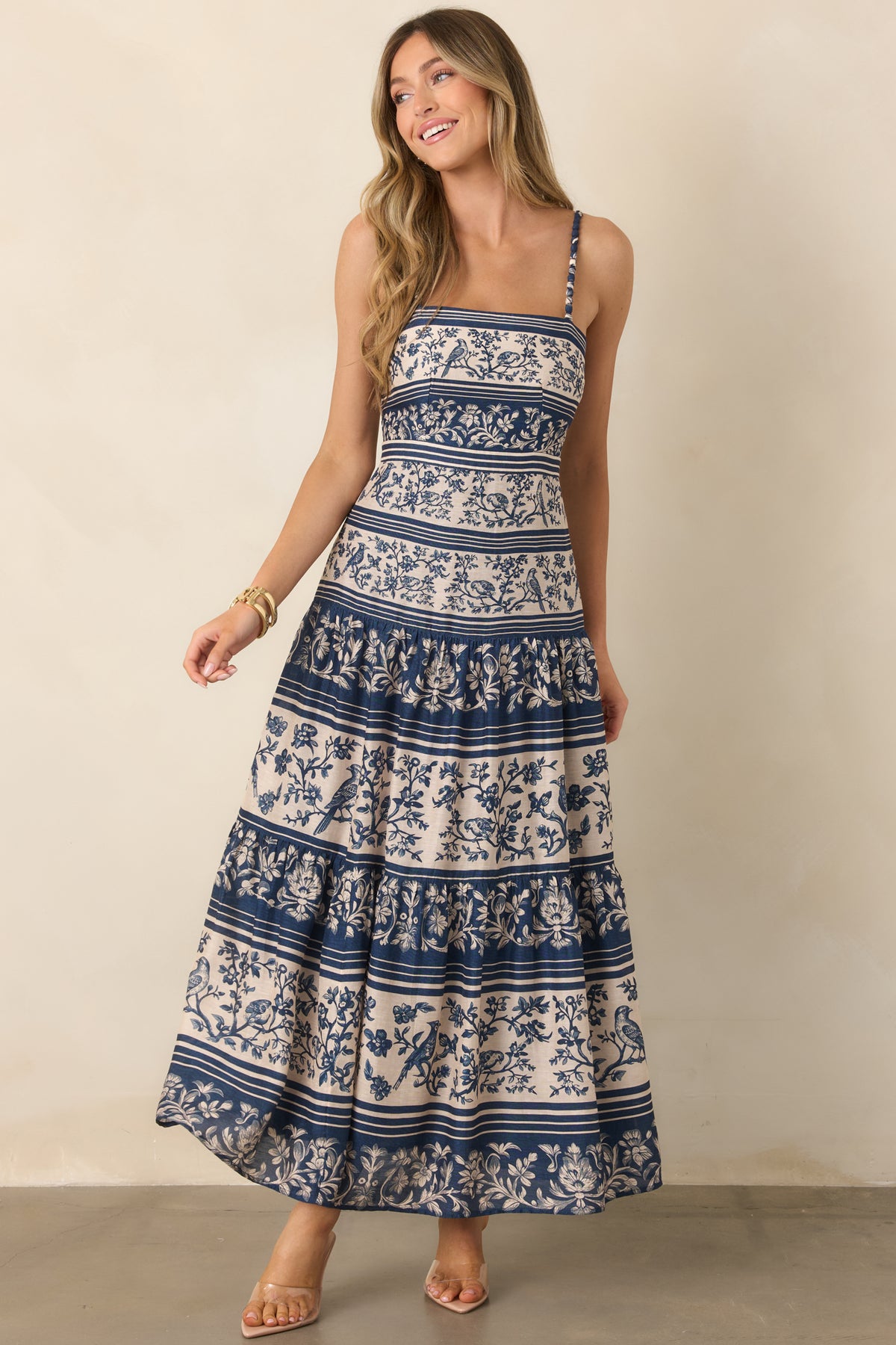A fitted blue and ivory patterned bodice flows into a full gathered skirt finished with multiple tiers.