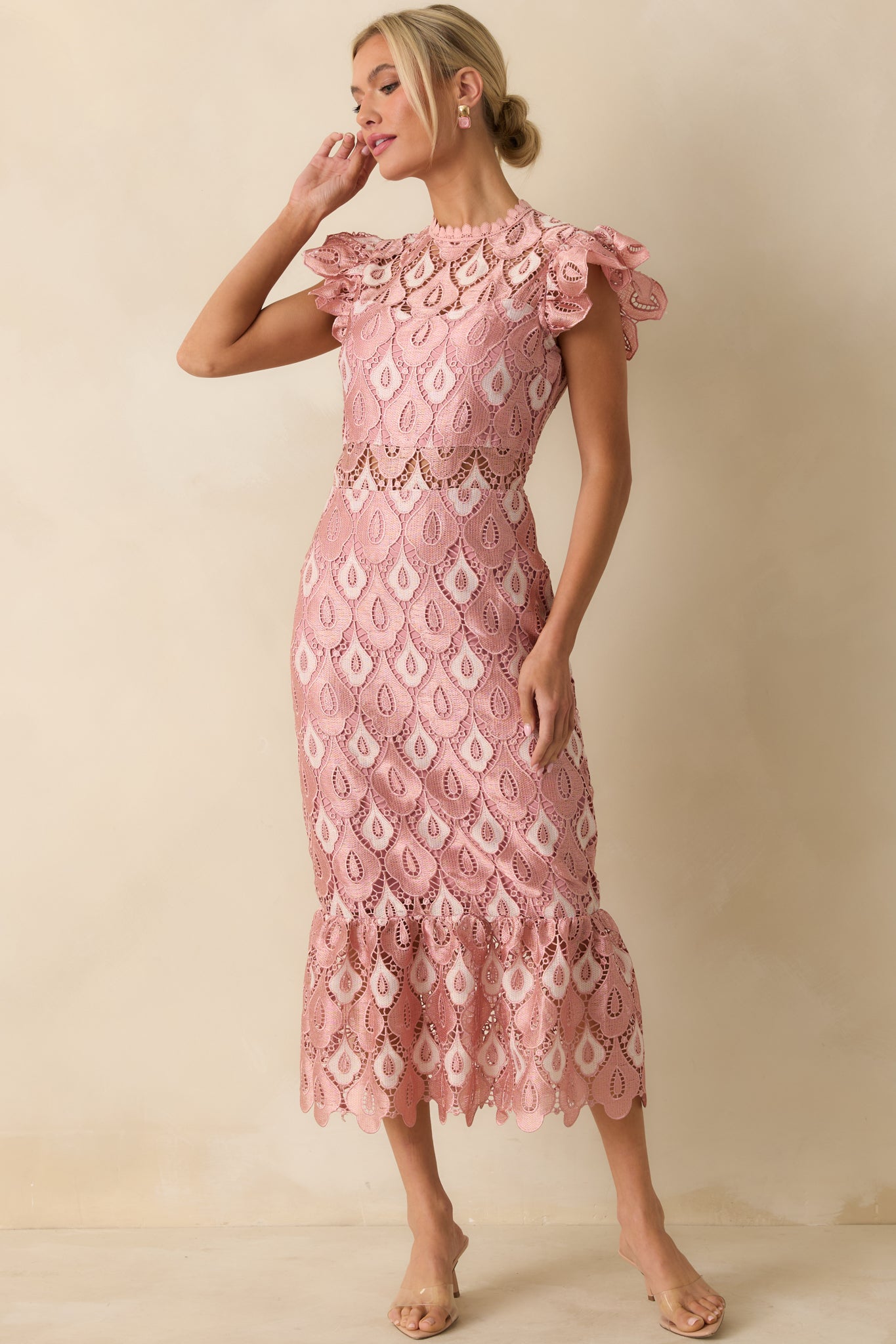 The dress showcases its fitted bodice, short sleeves, and flowing maxi skirt with scalloped lace edges and flounced hem.