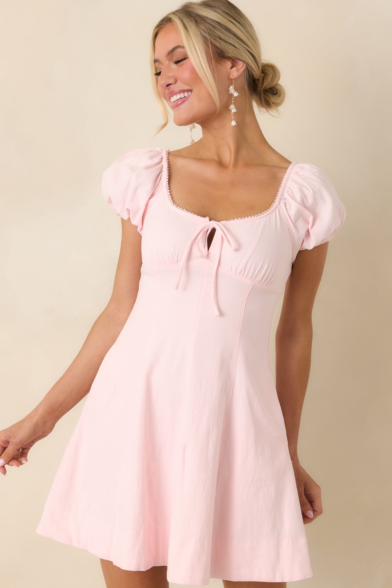 Fitted bodice with subtle seam shaping on a lightweight pink cotton mini dress.