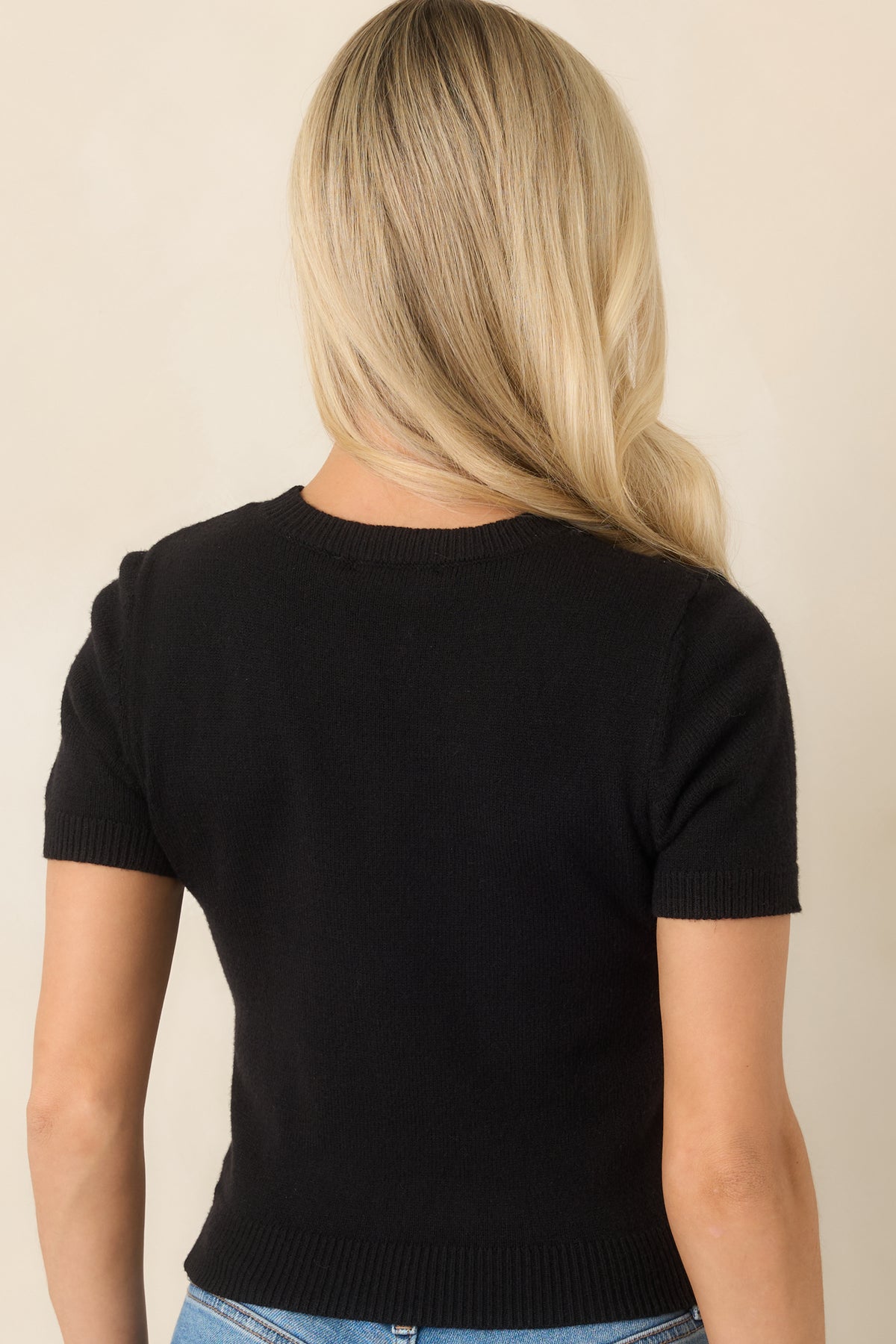 Rear of the fitted knit top showing the smooth silhouette and ribbed hem.