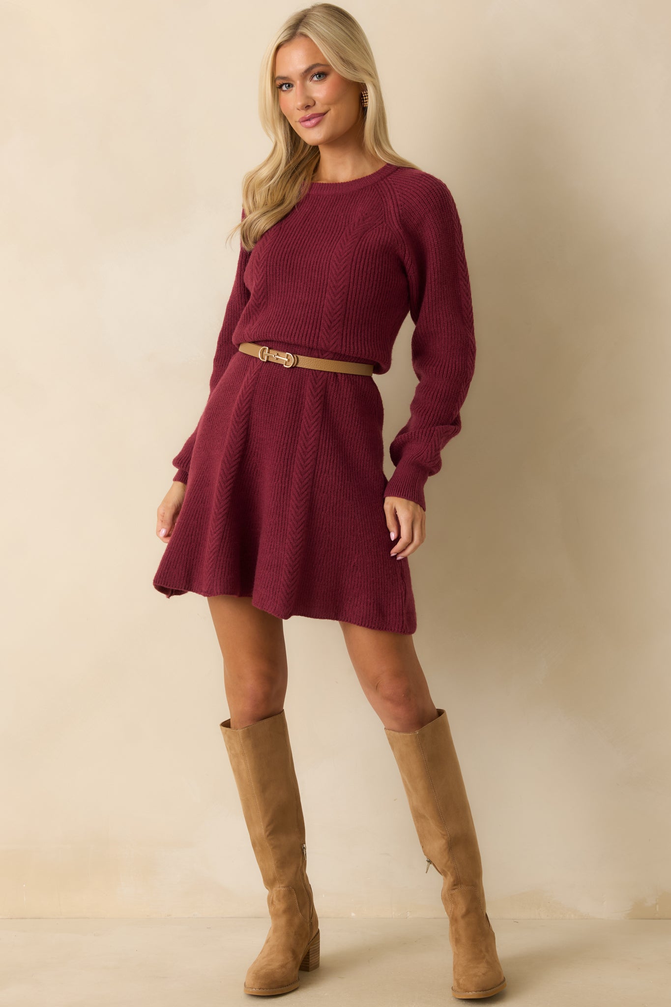 Fitted ribbed knit mini dress in burgundy with long sleeves, crew neckline, and a flared hemline.