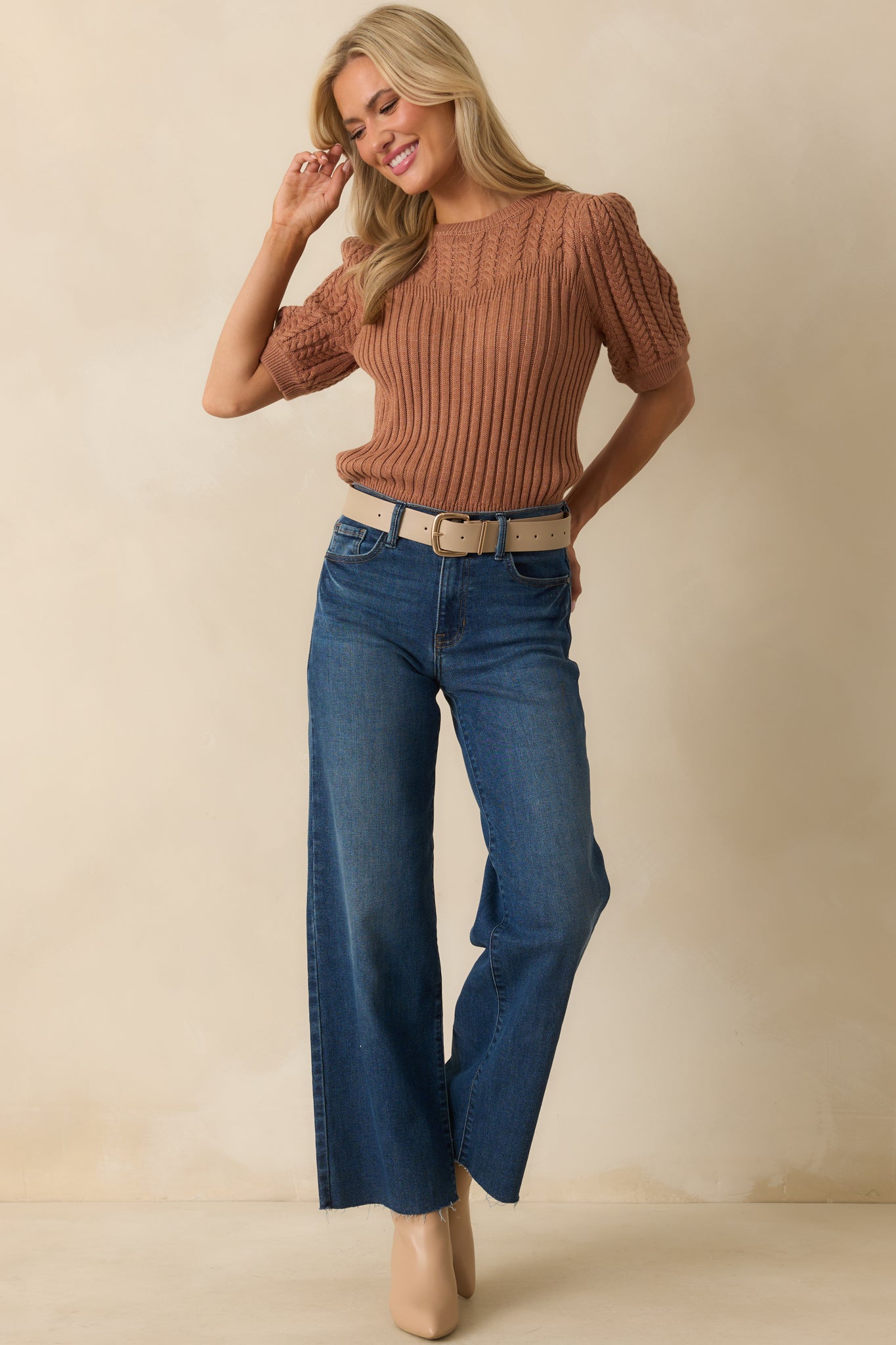 Fitted ribbed cuffs balance the puffed sleeves on the clay brown sweater.