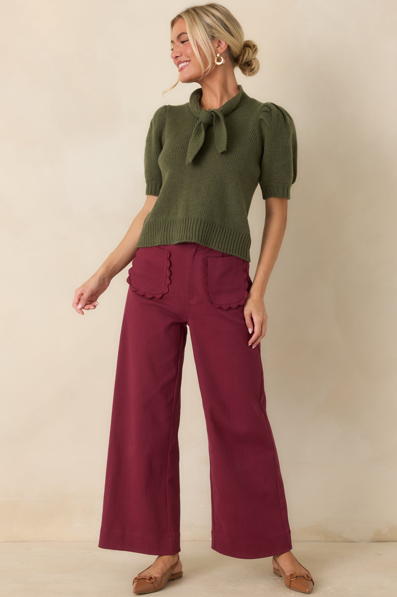 Fitted ribbed top showcasing a dramatic tie-neck detail, softly gathered sleeves, and a structured finish.