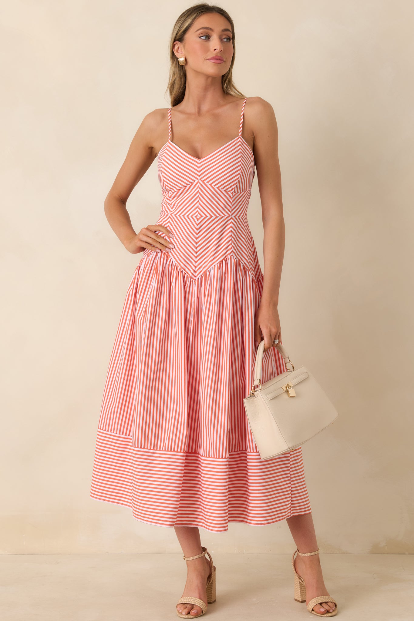 Fitted striped bodice flowing into a feminine midi-length skirt with clean lines.