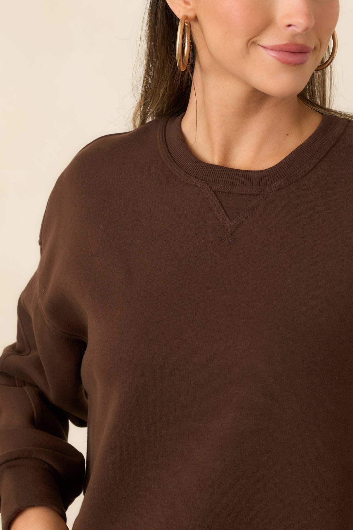 Close-up of the crew neckline’s ribbed trim and subtle V-stitch detail on the soft fleece top.