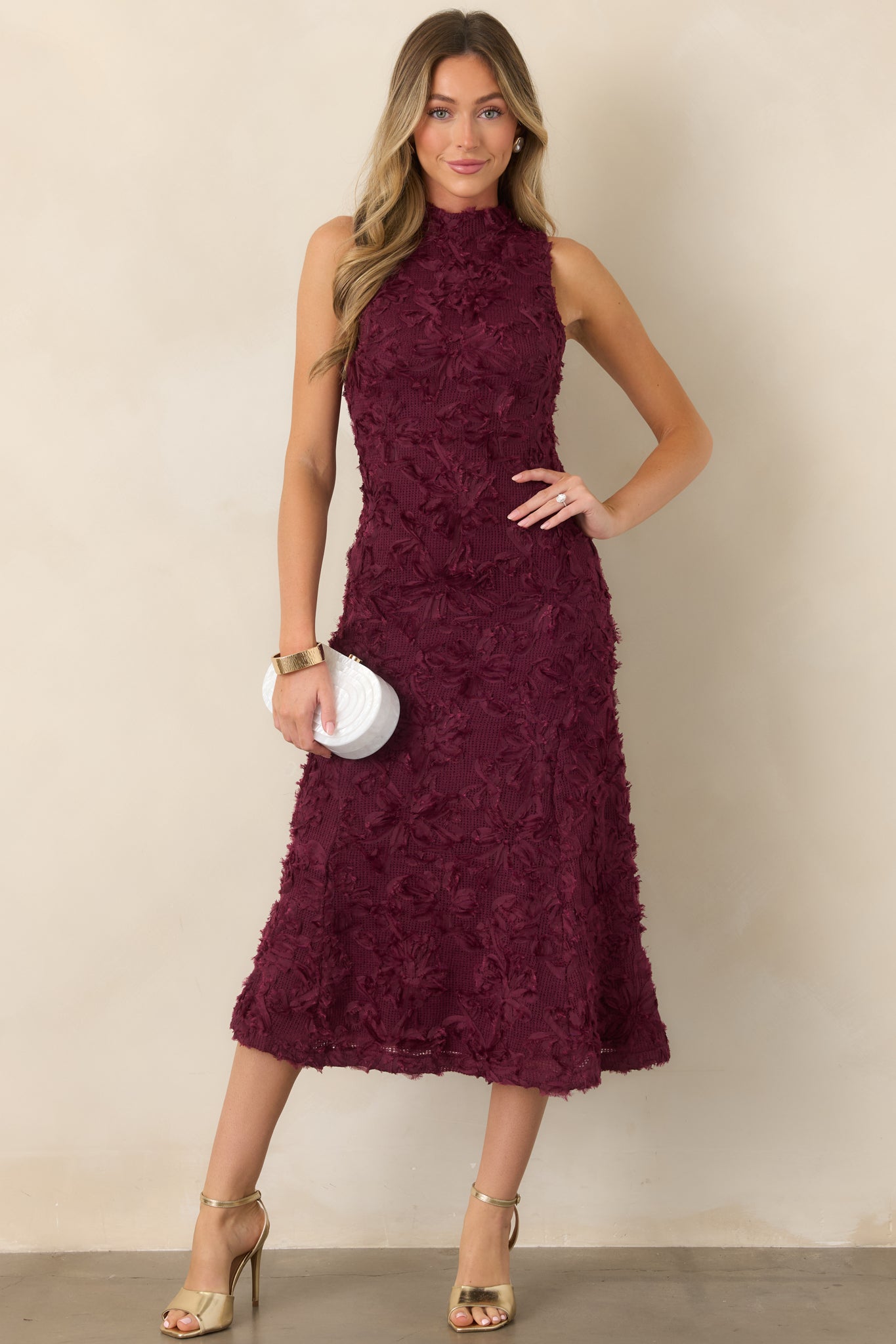 Floral appliqué knit midi dress featuring a high neckline, sleeveless silhouette, fitted bodice, and softly flared skirt.