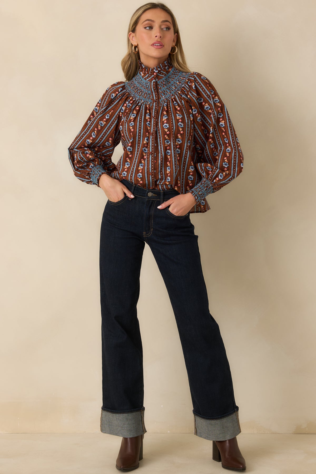 Floral blouse with contrasting blue smocking across the front yoke, fabric-covered buttons, and a relaxed gathered silhouette.