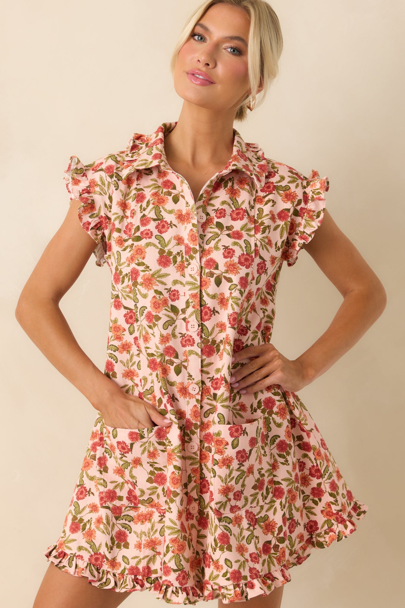 A front-facing image capturing the relaxed silhouette and dual front pockets of the floral mini dress.