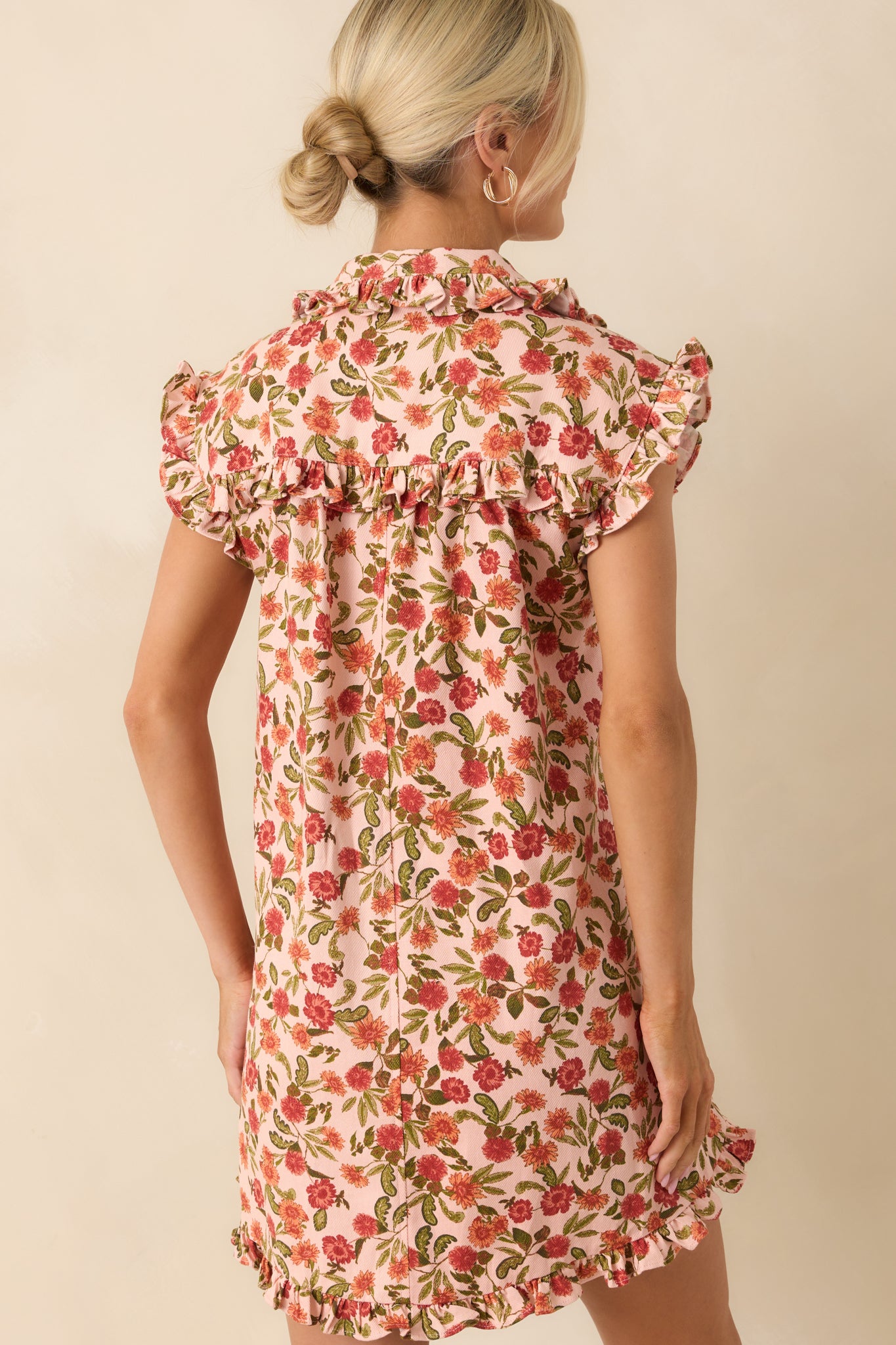 A back view of the dress featuring the floral pattern continuing throughout and subtle gathers along the hem.