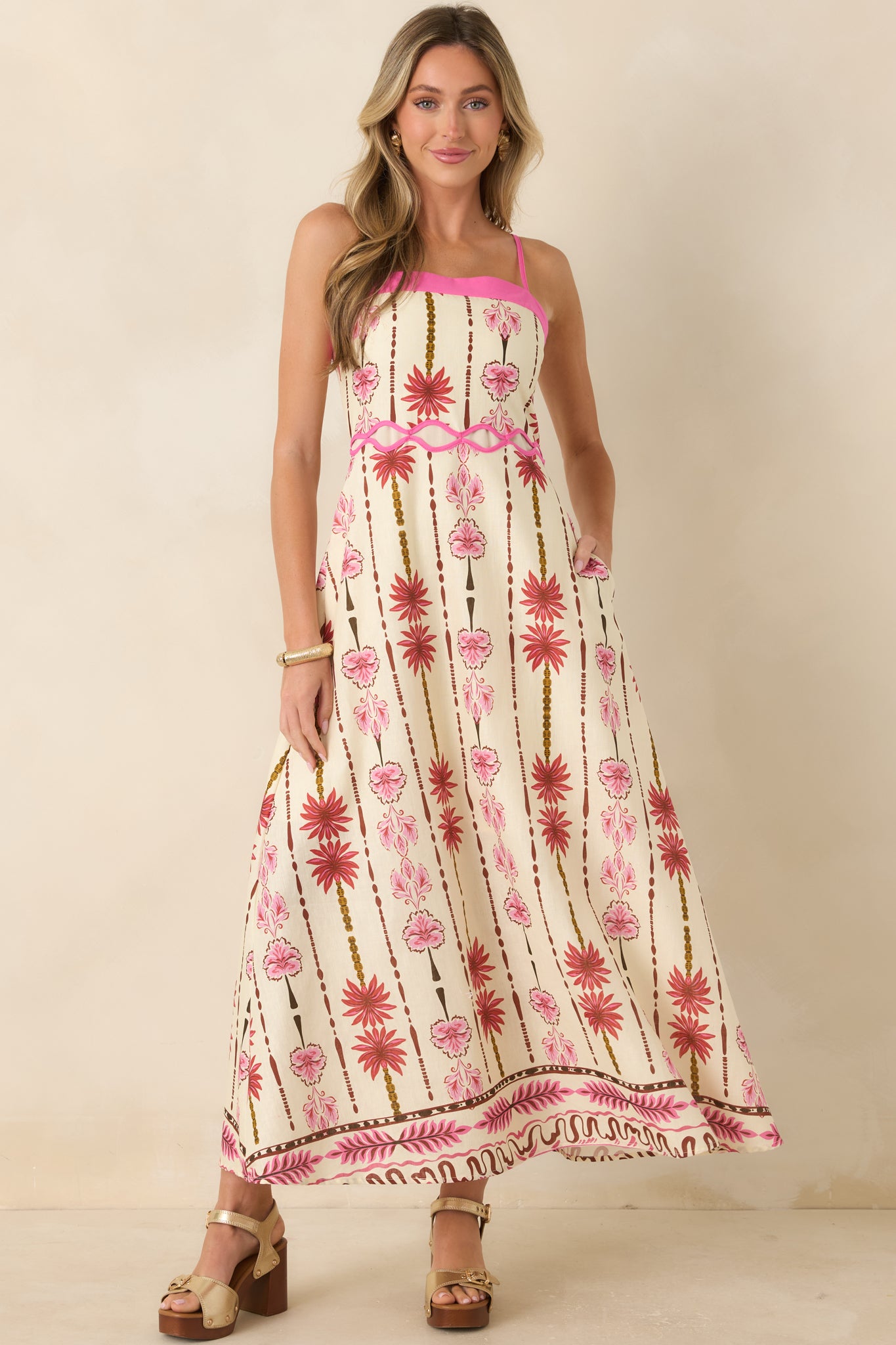 Floral cotton linen maxi dress featuring a straight neckline, adjustable straps, hot pink trim, and flowing A-line skirt.