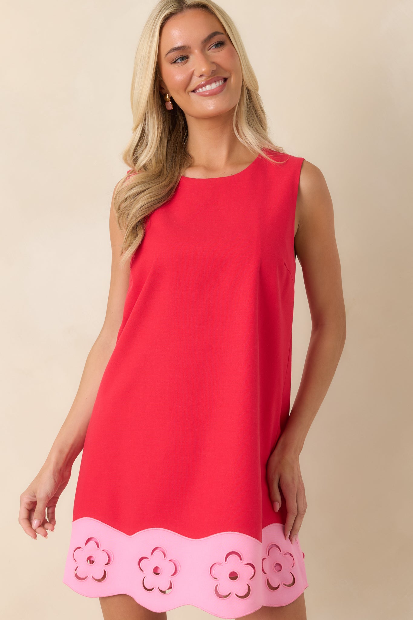 Focused view of the floral cutout hem detailing that adds contrast to the red mini dress.