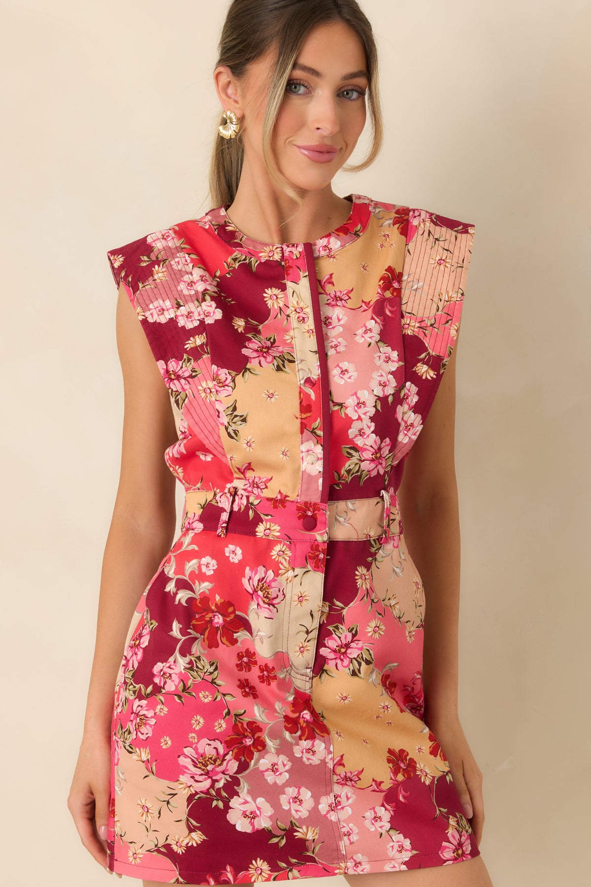 Functional side pocket on the cotton denim mini dress, surrounded by pink, peach, burgundy, and cream florals.