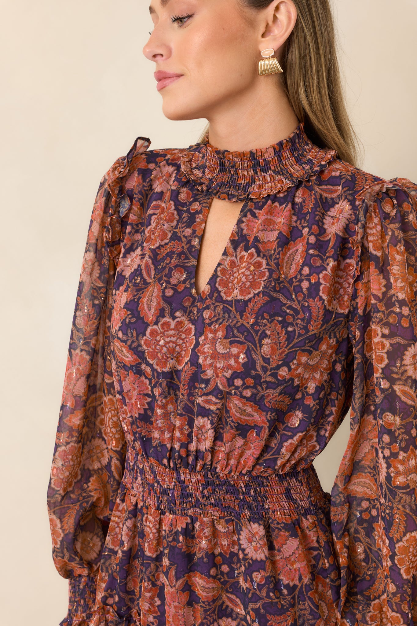 Close-up of the smocked high neckline, delicate keyhole opening, and detailed floral overlay.