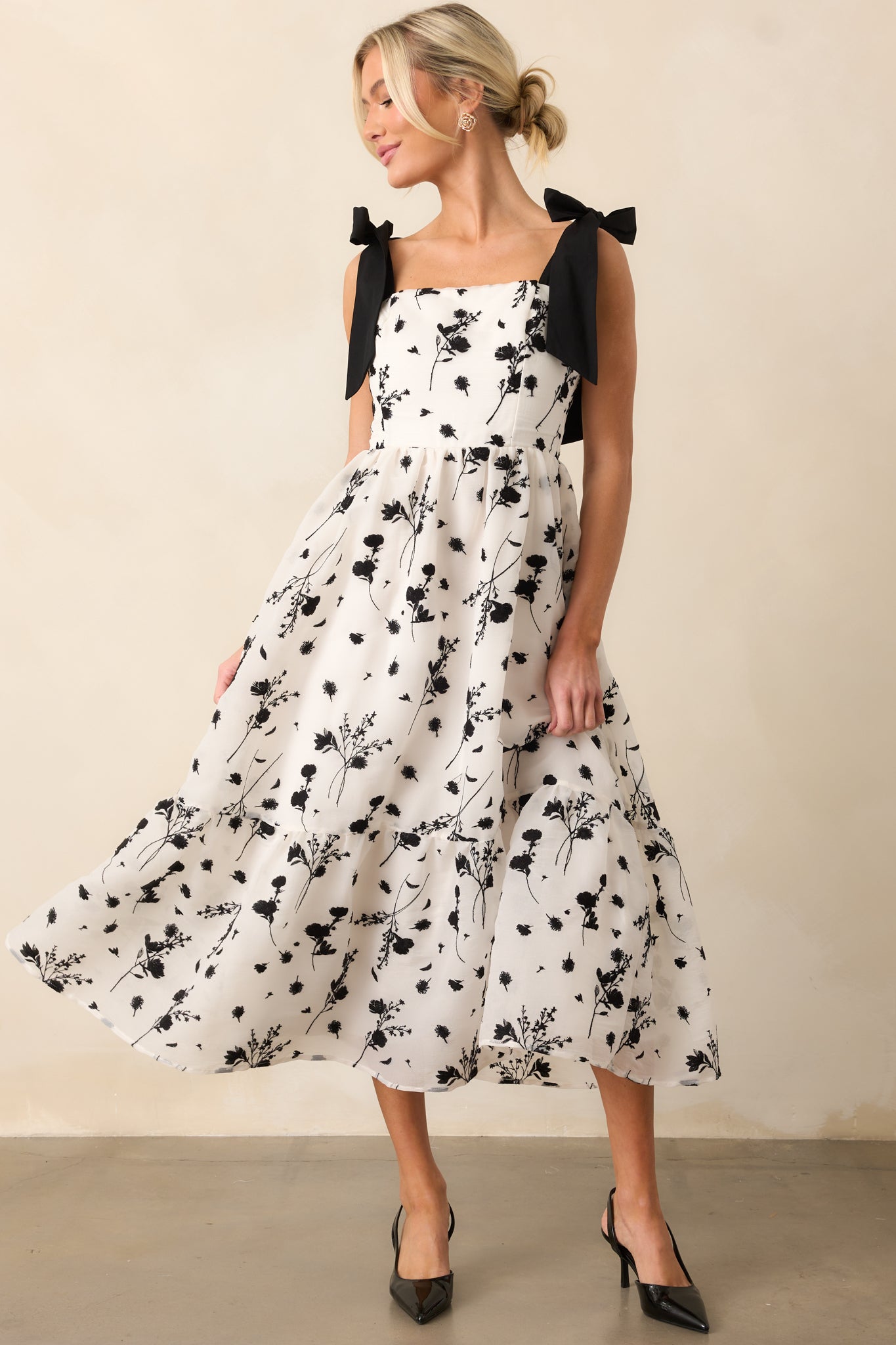 A floral-embroidered midi dress with a square neckline, adjustable straps, and a flattering smocked back panel for a perfect silhouette.