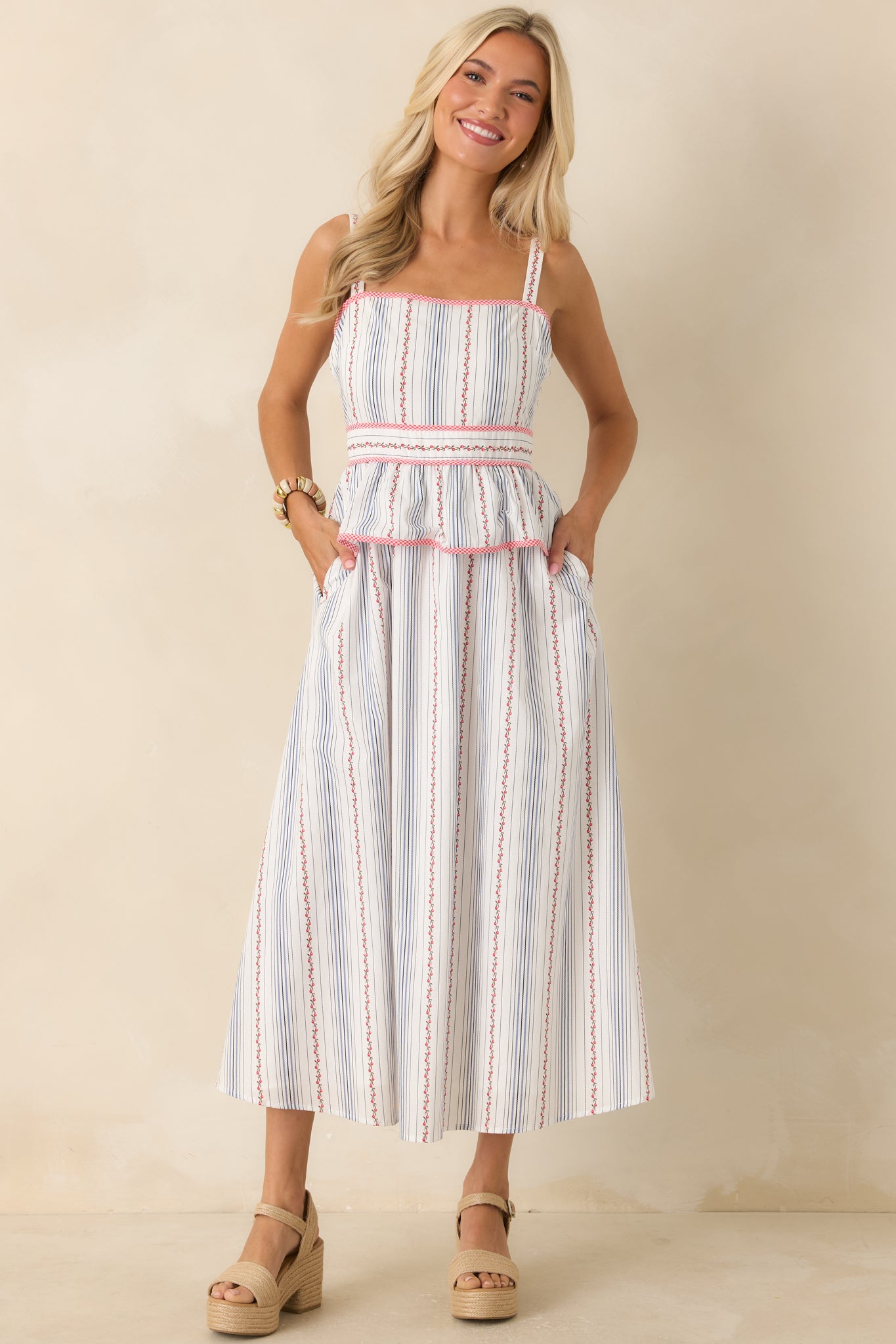 Feminine midi dress showcasing a delicate floral stripe print, gingham accents, a fitted waist, and an easy flowing silhouette.