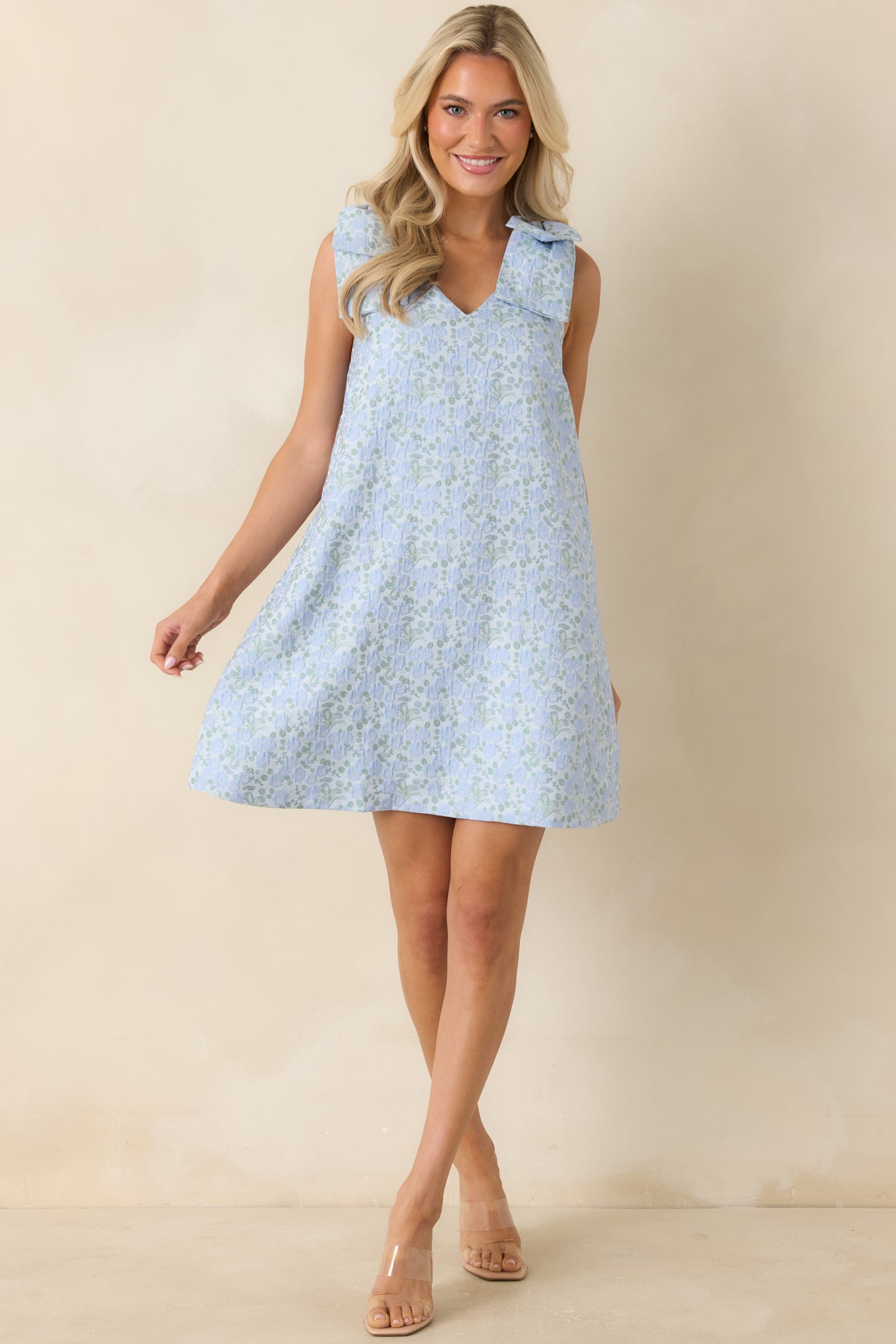 Floral jacquard mini dress featuring a v-neckline and statement shoulder bows for a playful, feminine design.