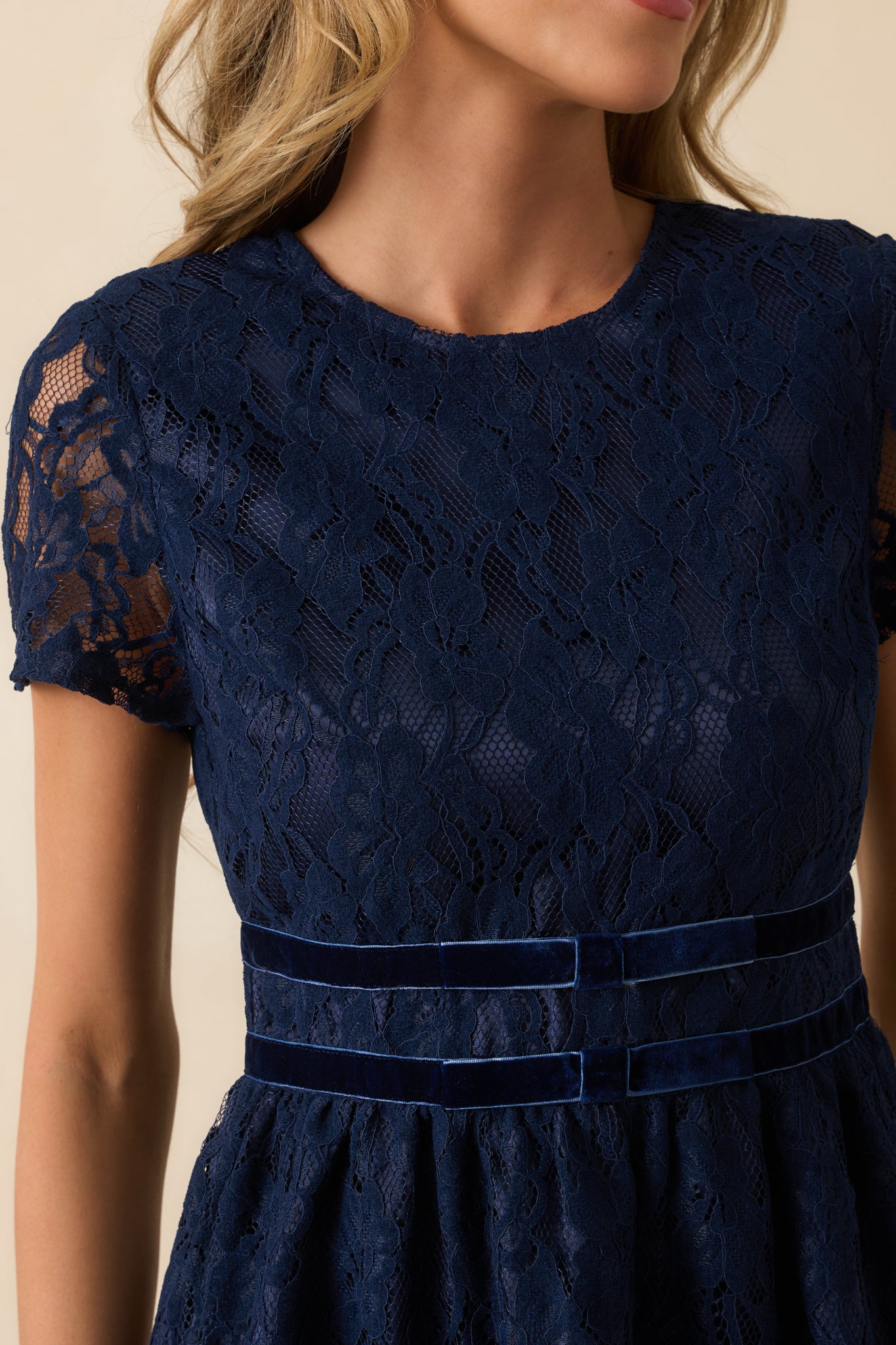 Close view of the floral lace fabric and velvet trim bands, showing the intricate texture and craftsmanship.