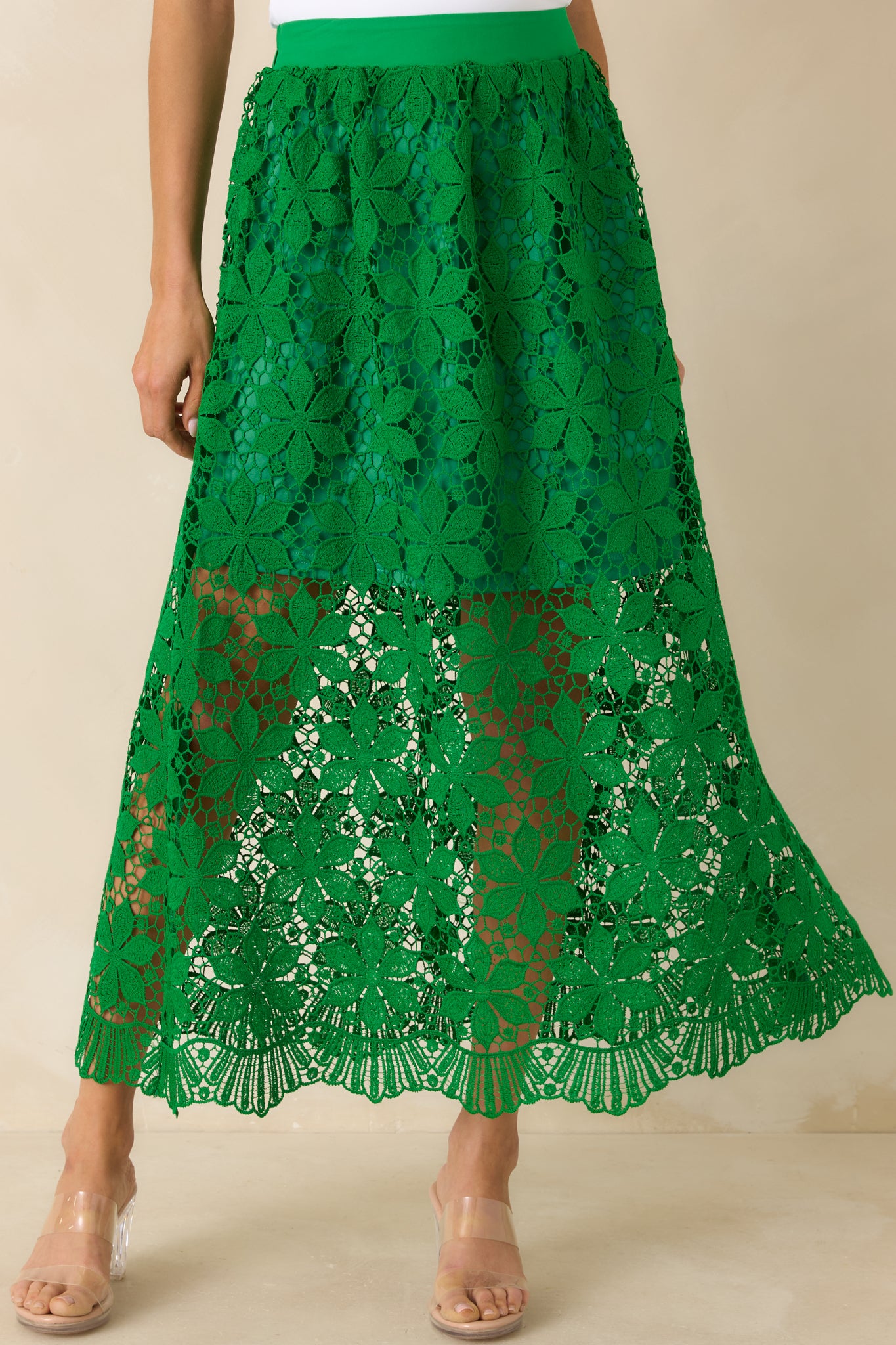 Floral lace overlay on green maxi skirt with scalloped hem finish.