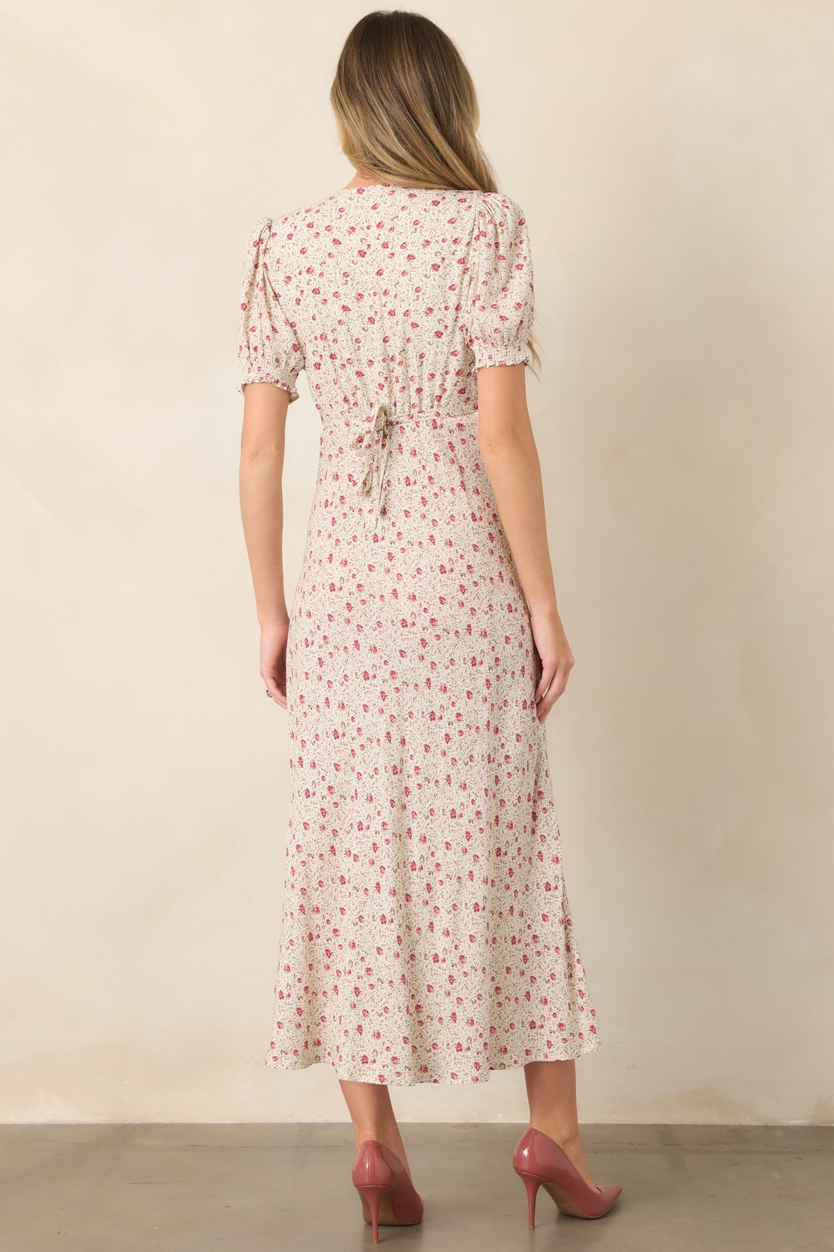 Rear view of the floral maxi dress showcasing the self-tie back, elastic waist, puff sleeves, and flowing skirt.