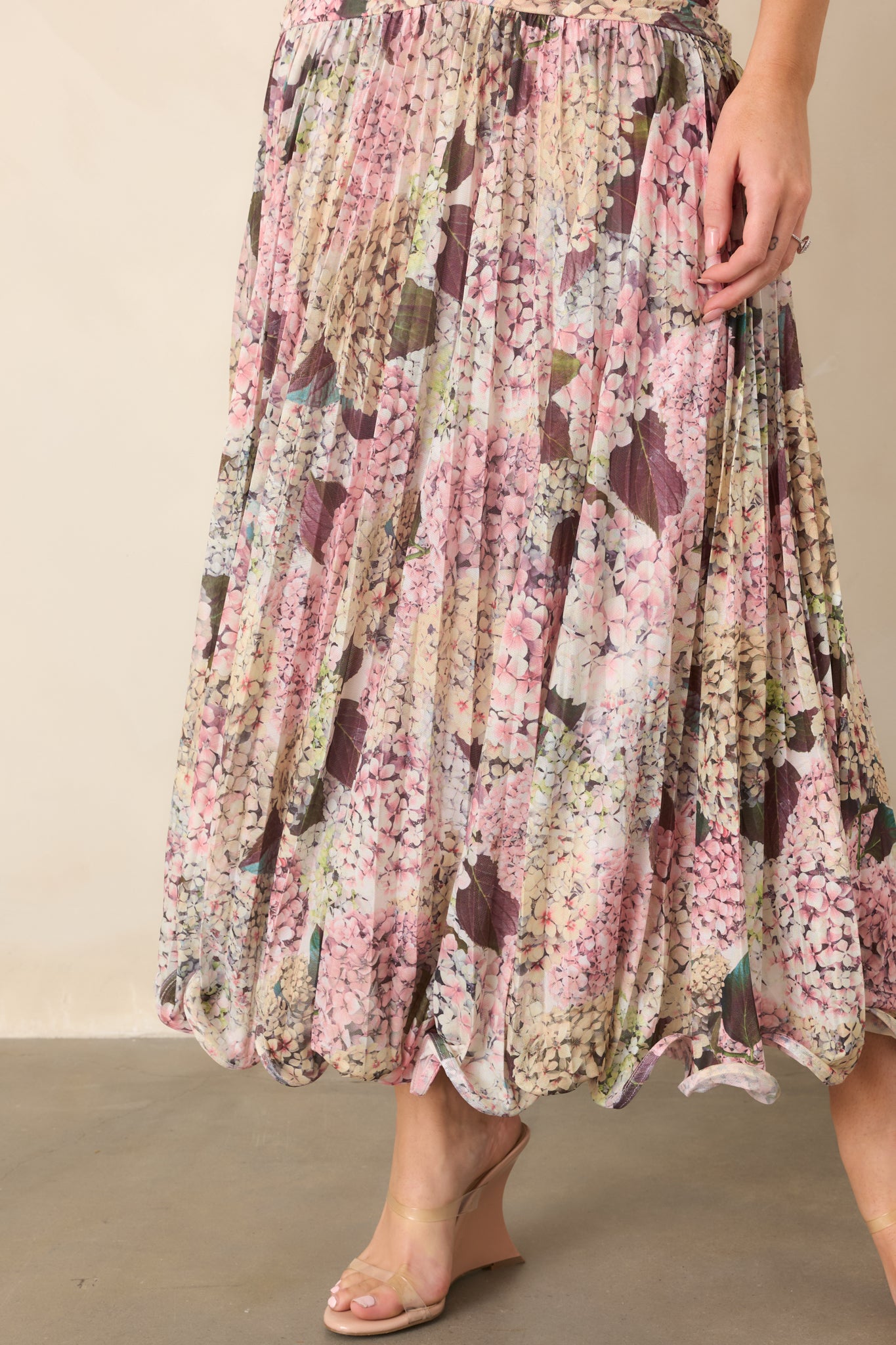 Close-up of the maxi dress hem showcasing the structured wavy edge and softly gathered floral fabric for added movement.