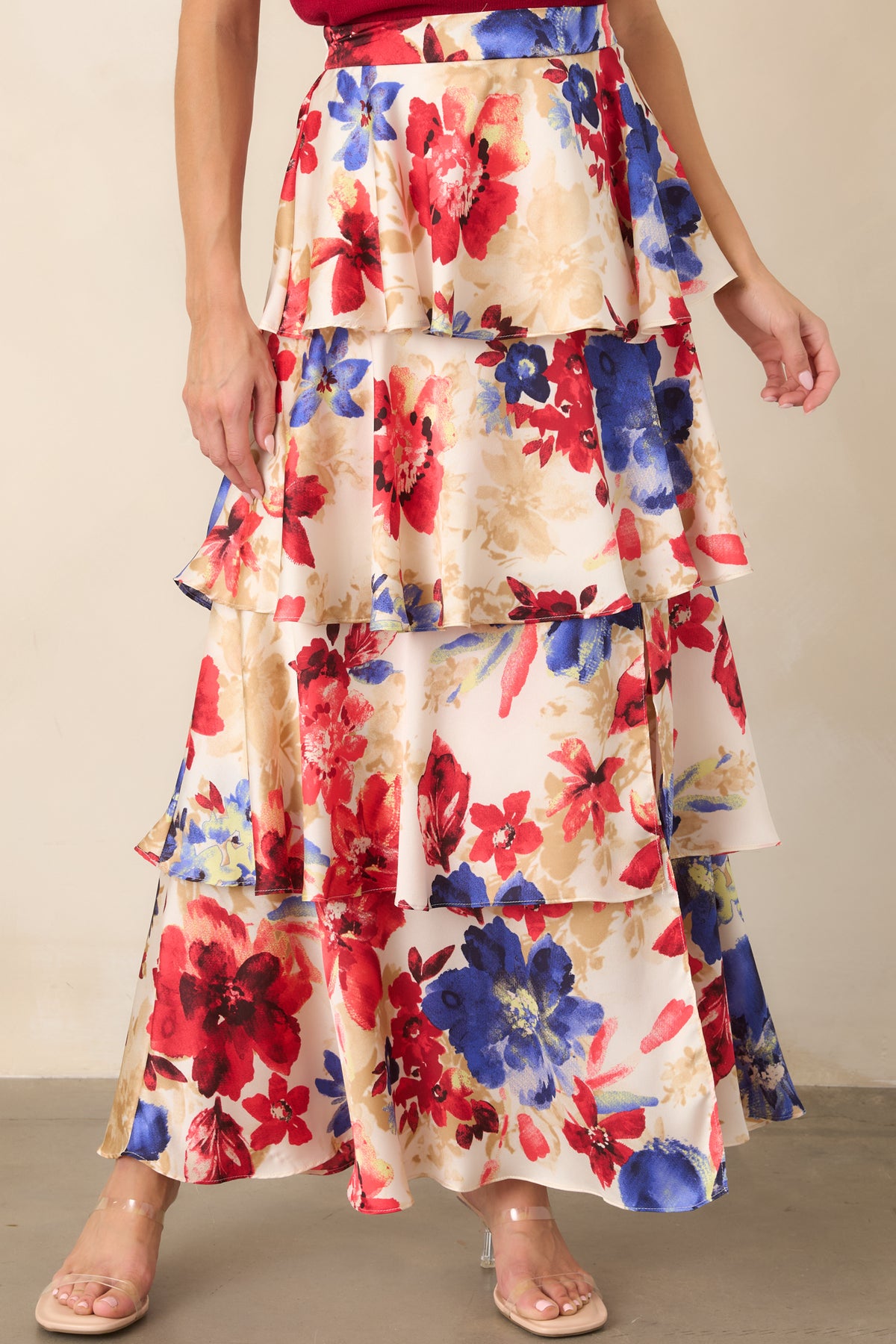 Detailed view of the skirt's elastic waistband and gathered upper tier against the ivory floral-print fabric.