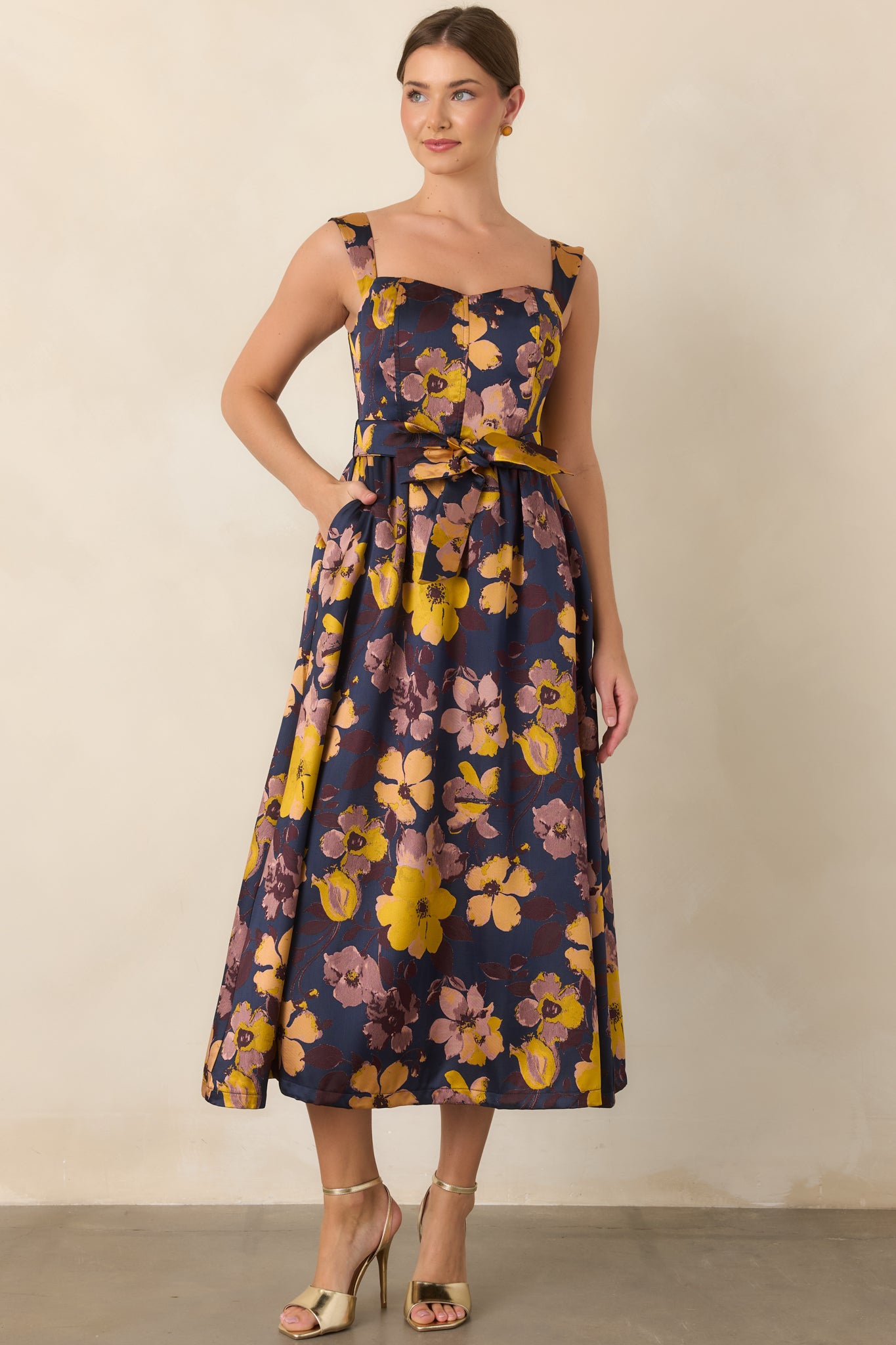 Floral midi dress showcasing its structured square neckline, wide shoulder straps, and defined waistline.