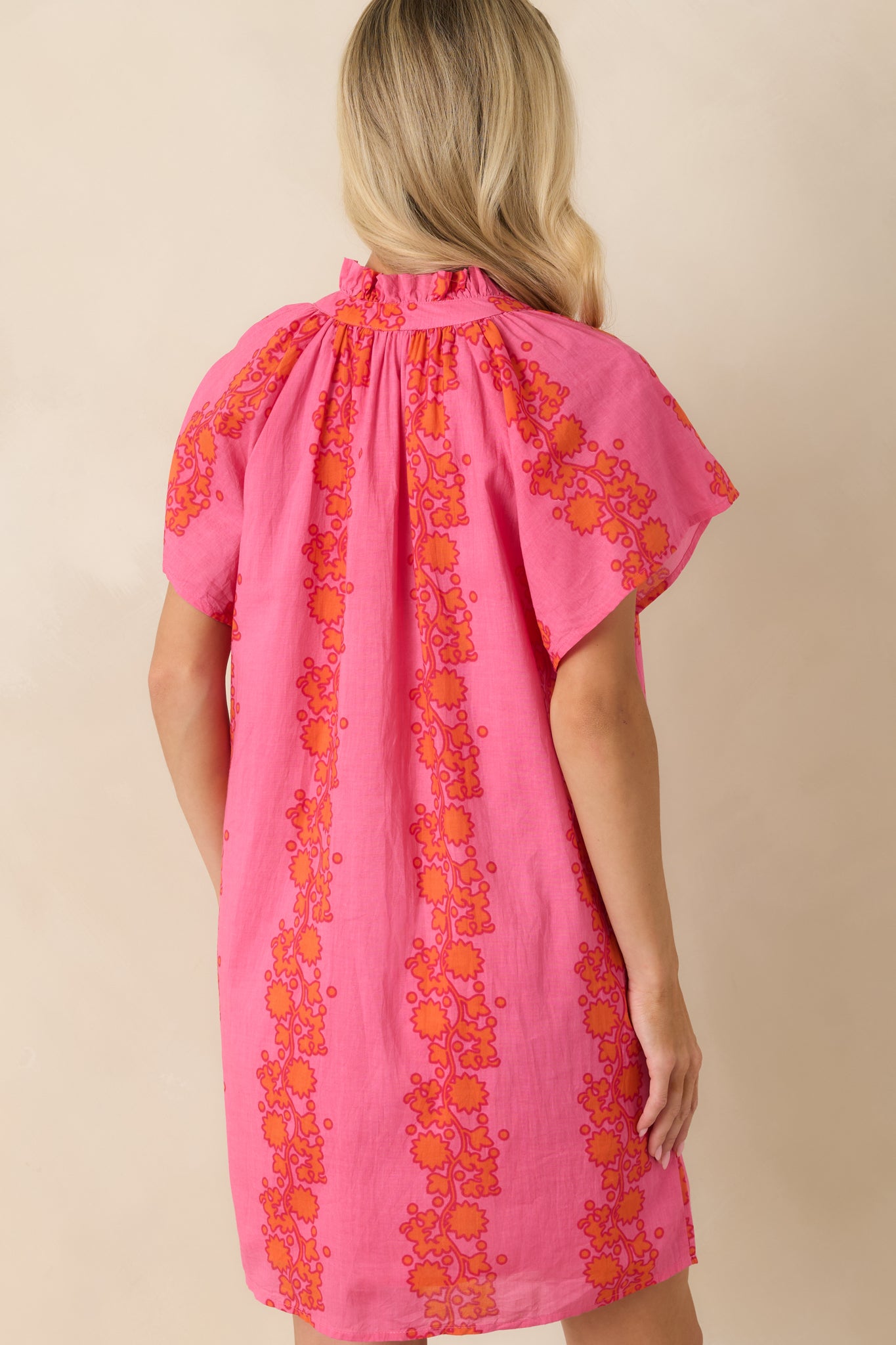 Back view of the floral mini dress featuring a relaxed shift silhouette and short sleeves.